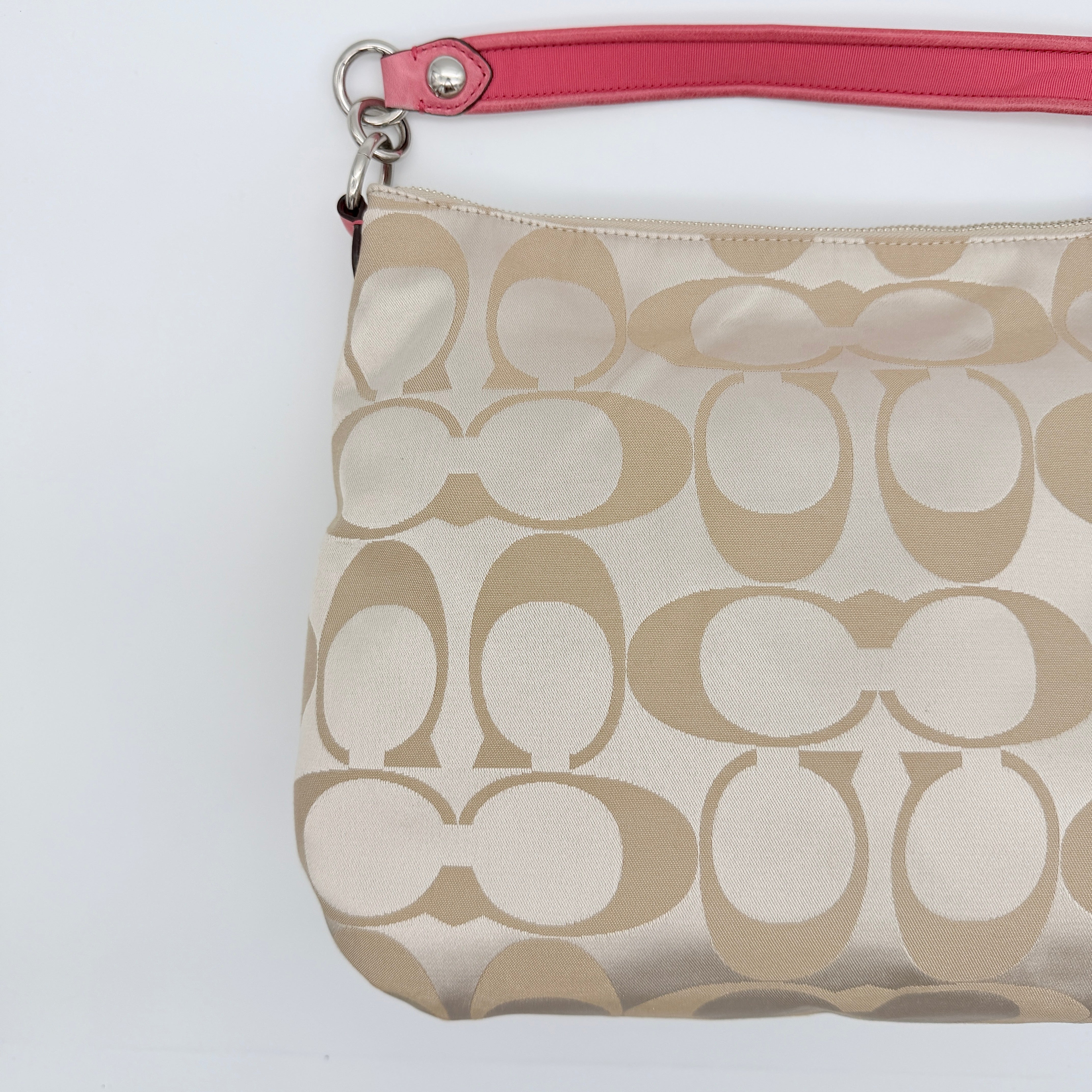 Coach Signature Poppy Pocket Hobo in beige sateen canvas with pink leather trim and silver hardware, front view with double pockets and charms.