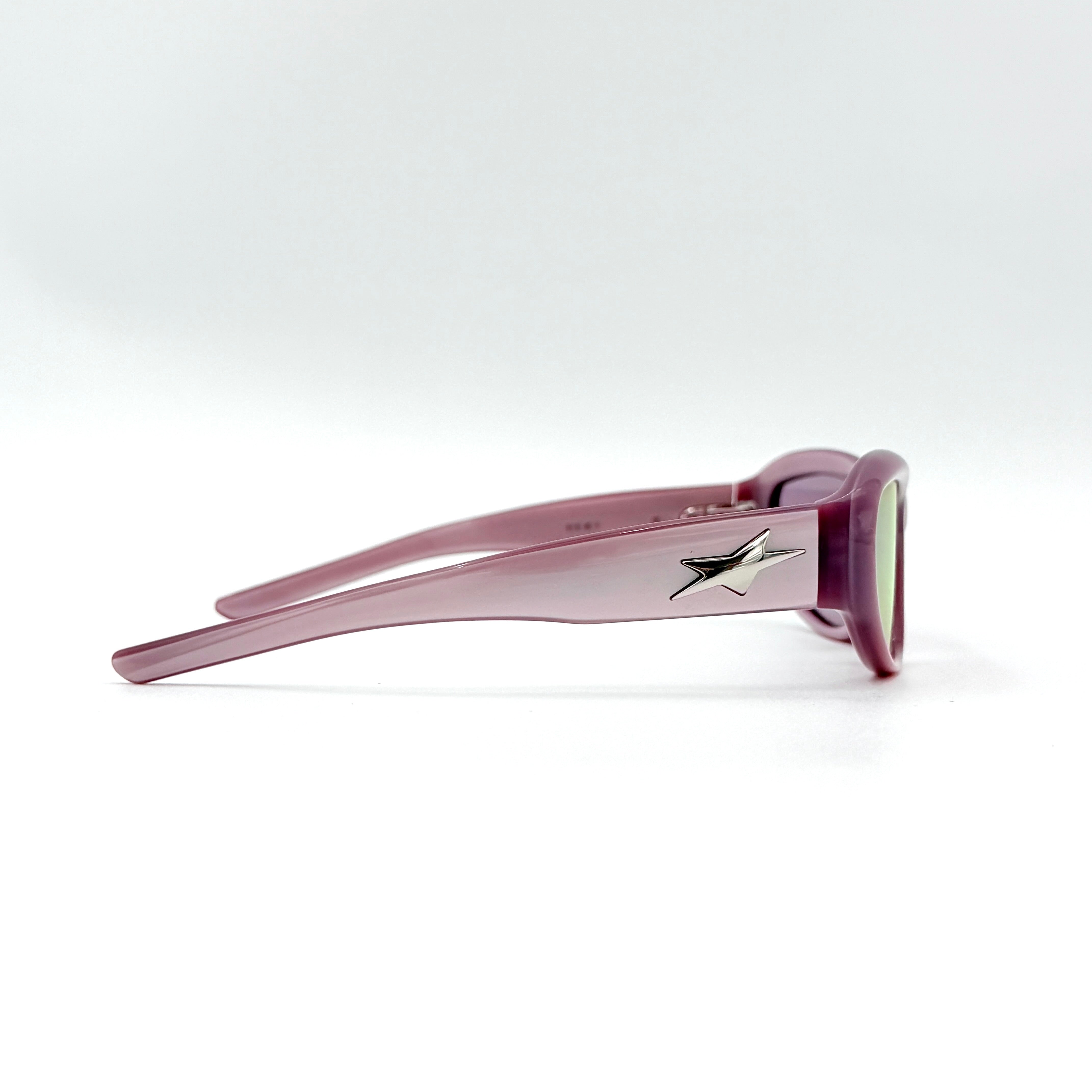 Gentle Monster R.E.A.T sunglasses in translucent pink acetate with mirrored pink lenses and silver star hardware, displayed alongside a chrome hard case.