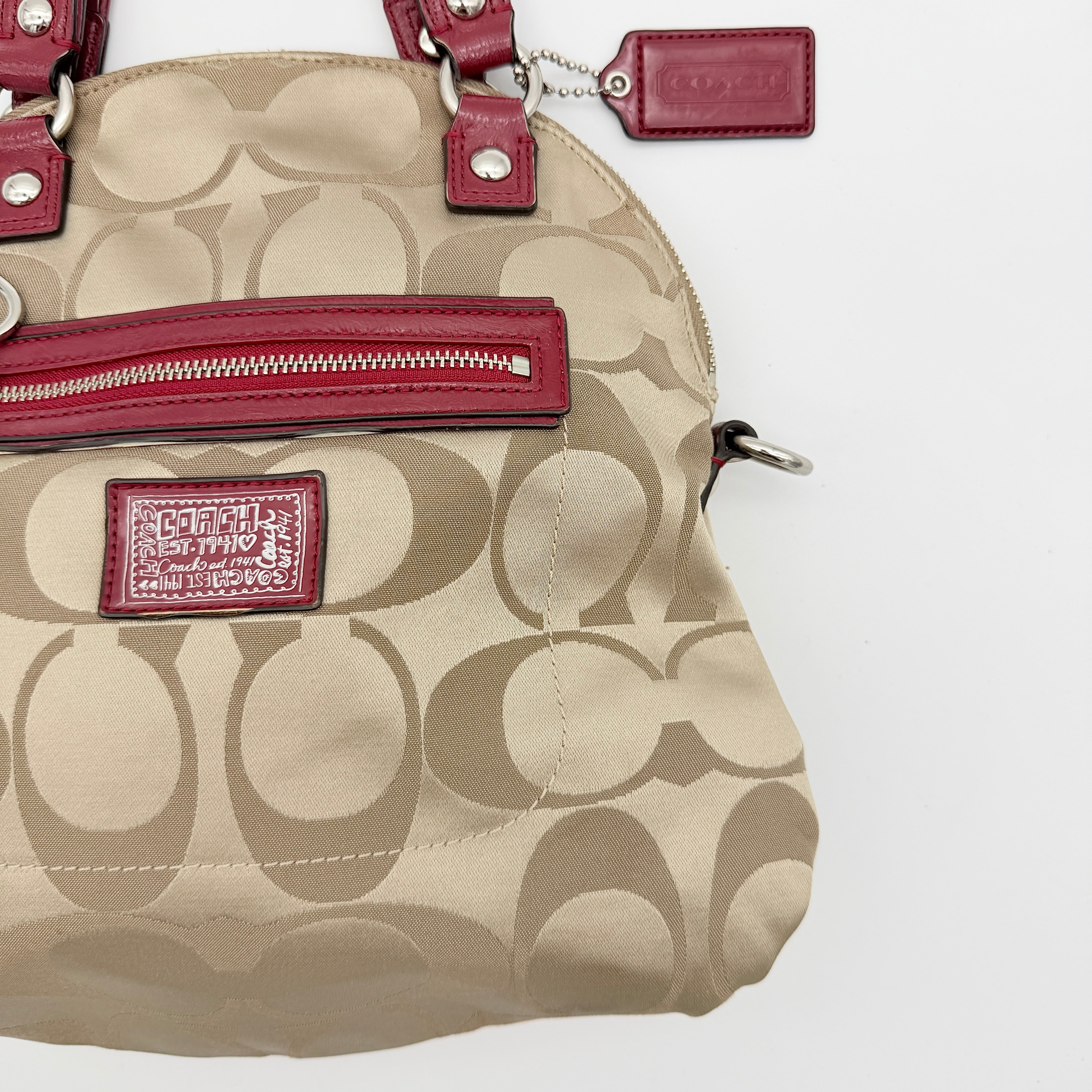 Coach Signature Poppy satchel in beige jacquard with red leather trim and detachable strap, shown with silver-tone hardware.