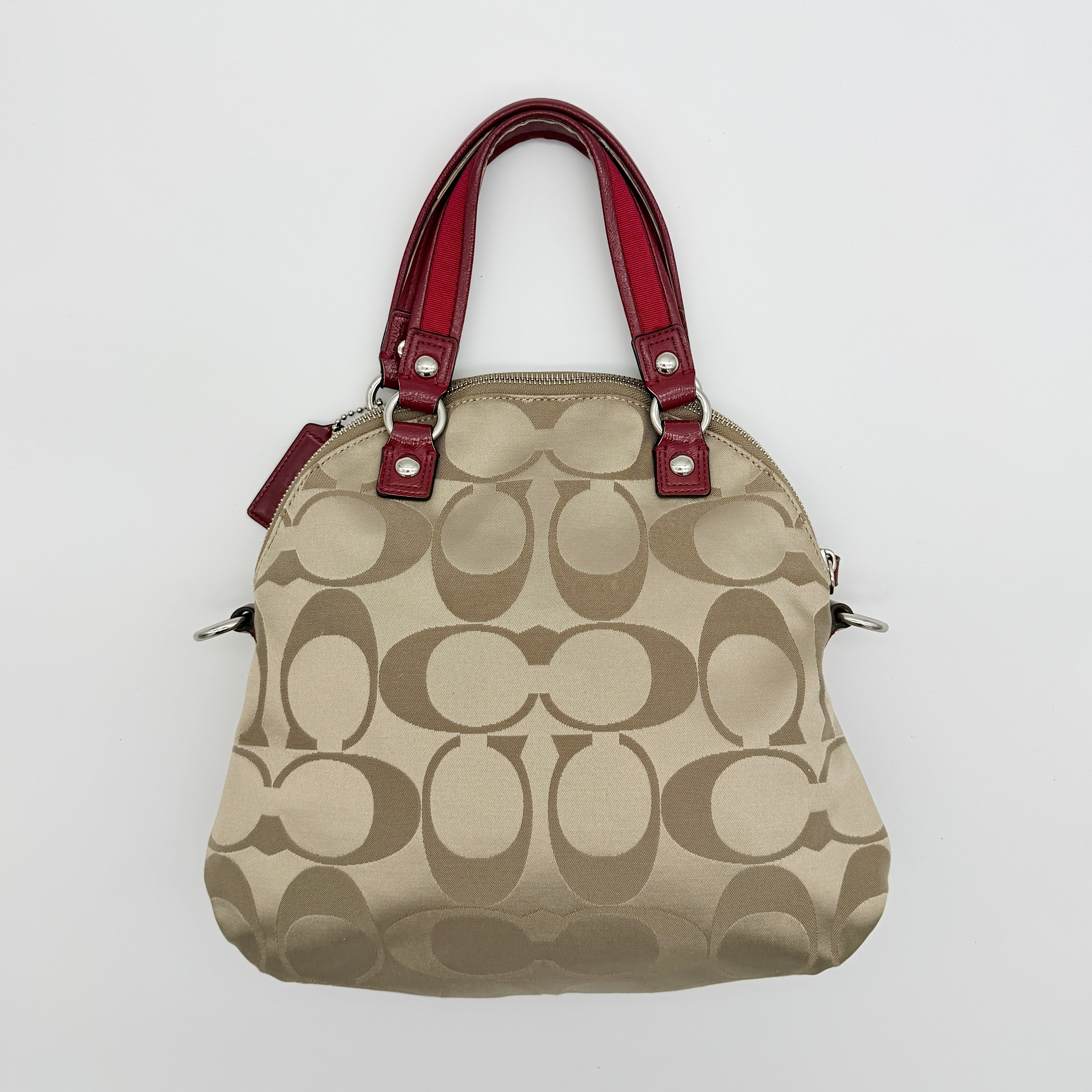 Coach Signature Poppy satchel in beige jacquard with red leather trim and detachable strap, shown with silver-tone hardware.