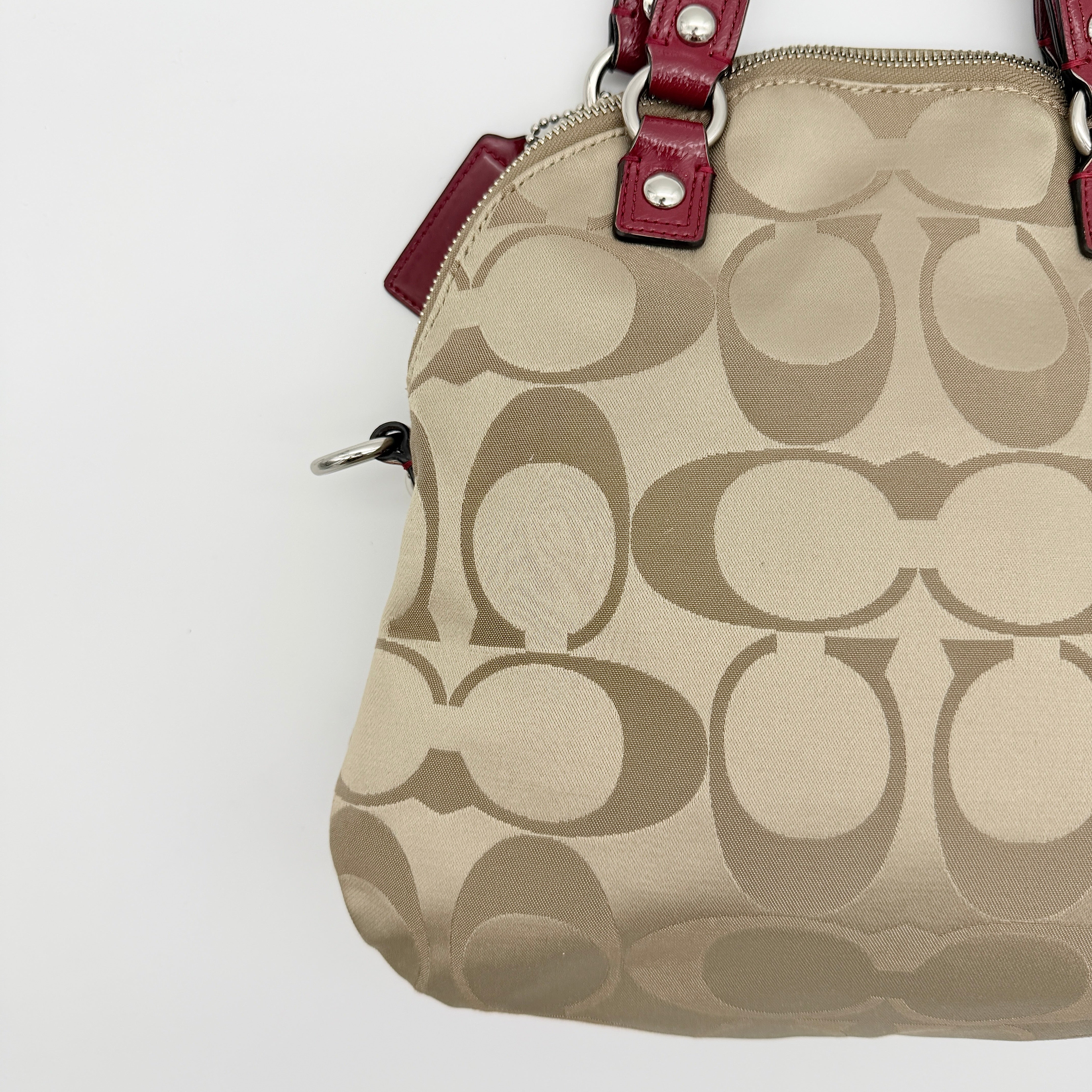 Coach Signature Poppy satchel in beige jacquard with red leather trim and detachable strap, shown with silver-tone hardware.