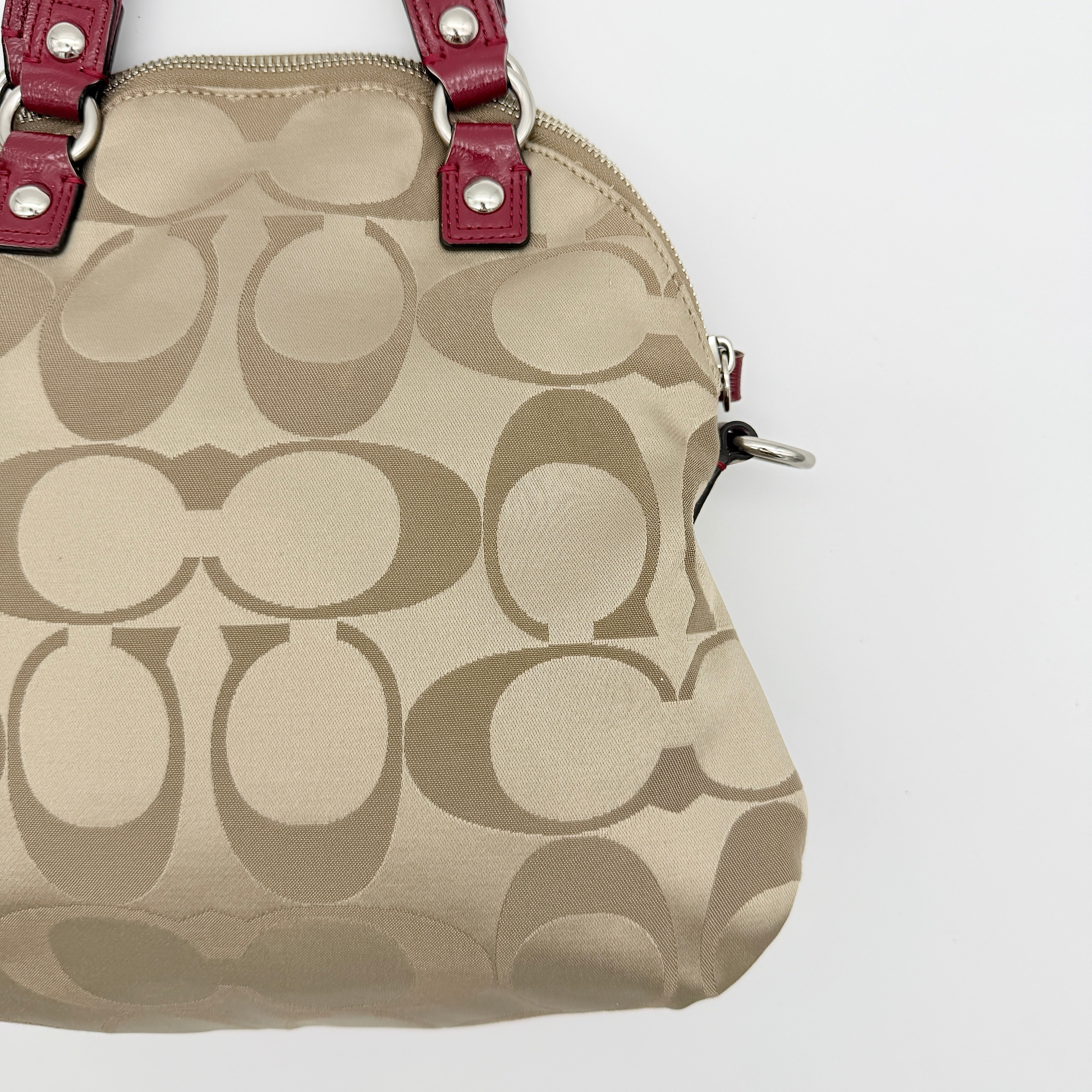 Coach Signature Poppy satchel in beige jacquard with red leather trim and detachable strap, shown with silver-tone hardware.
