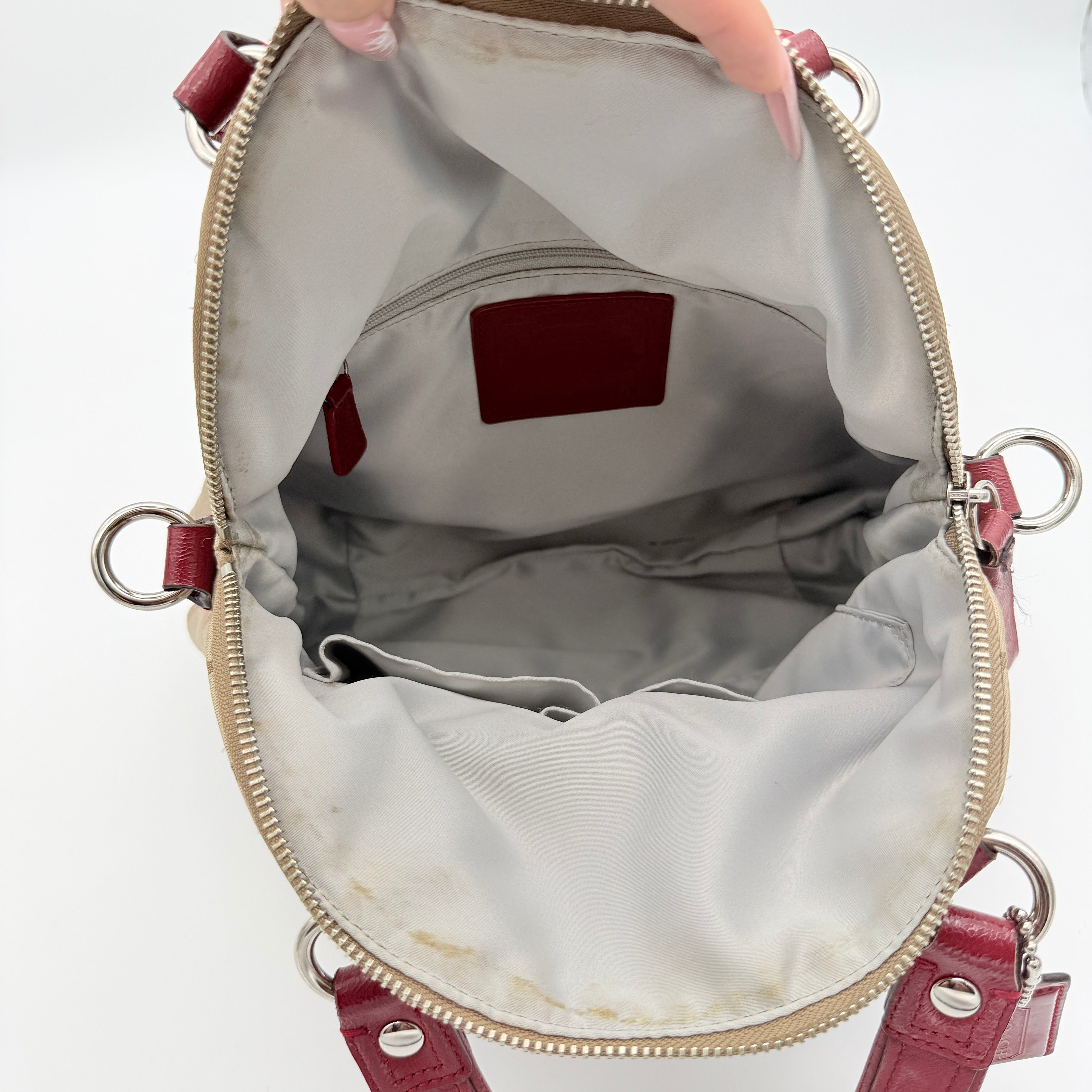 Coach Signature Poppy satchel in beige jacquard with red leather trim and detachable strap, shown with silver-tone hardware.