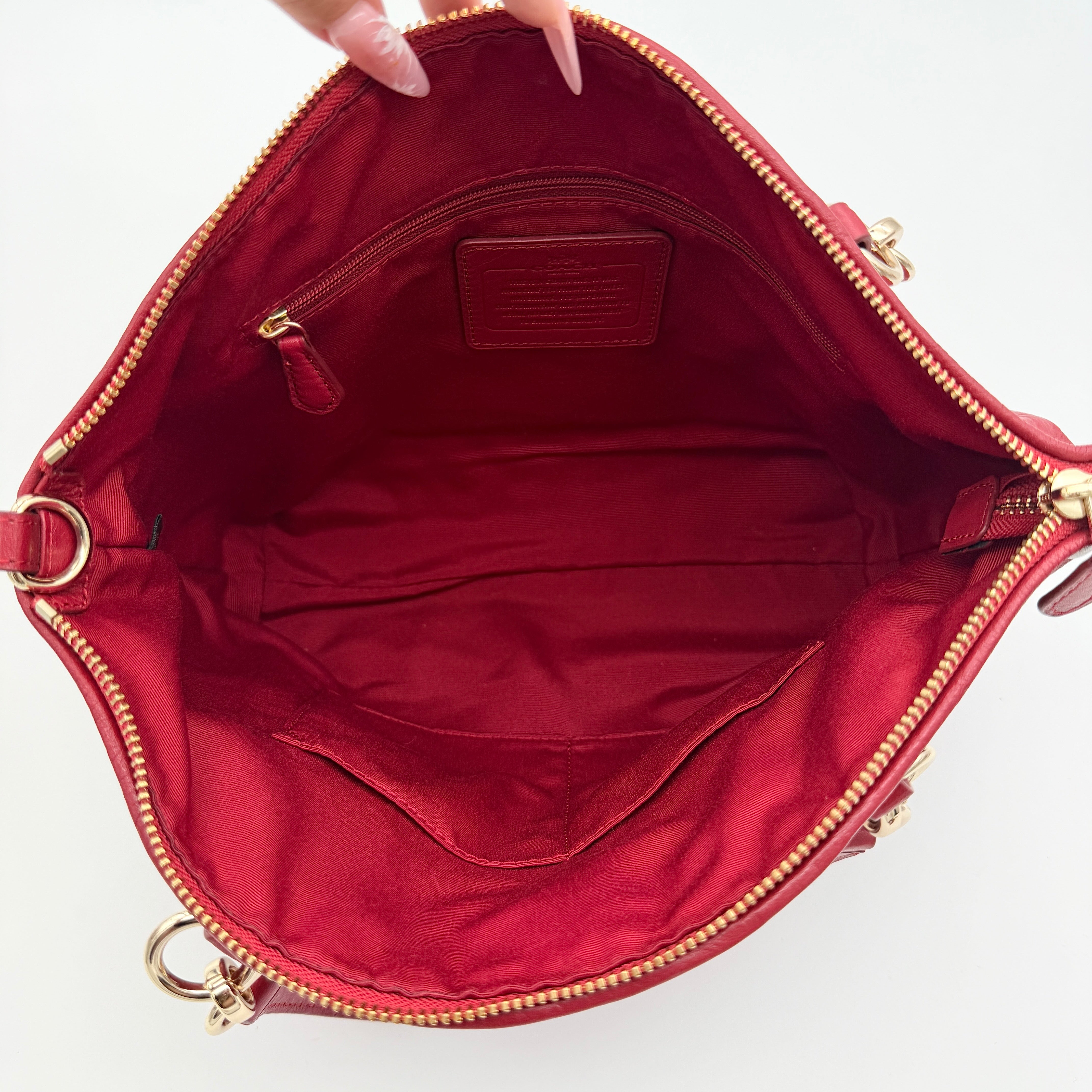 Coach Kelsey 2Way satchel in quilted red leather with gold-tone hardware and detachable strap, displayed against a white background.