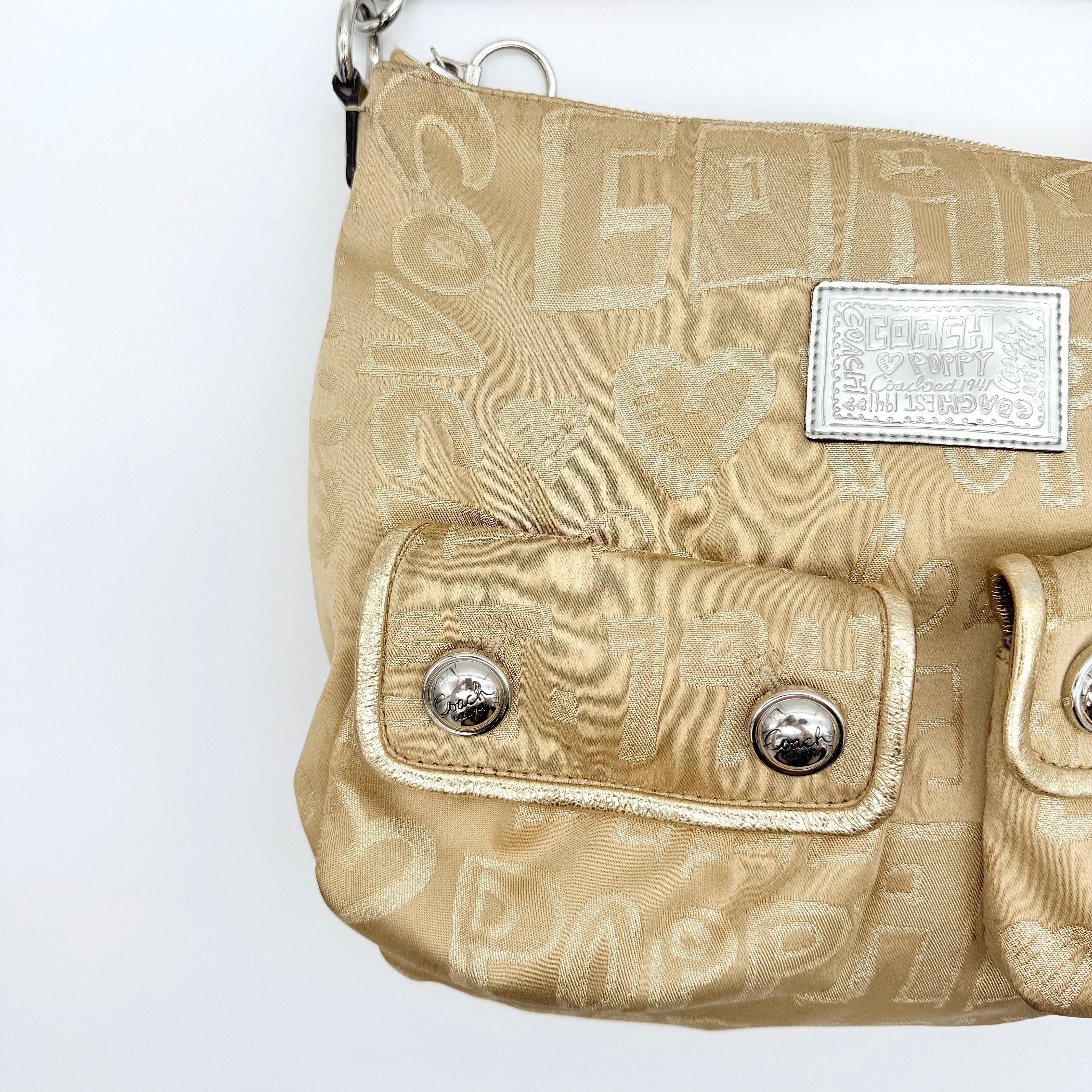 Coach Signature Poppy Pocket Hobo in beige sateen with metallic gold trim and silver hardware, shown with detachable strap.