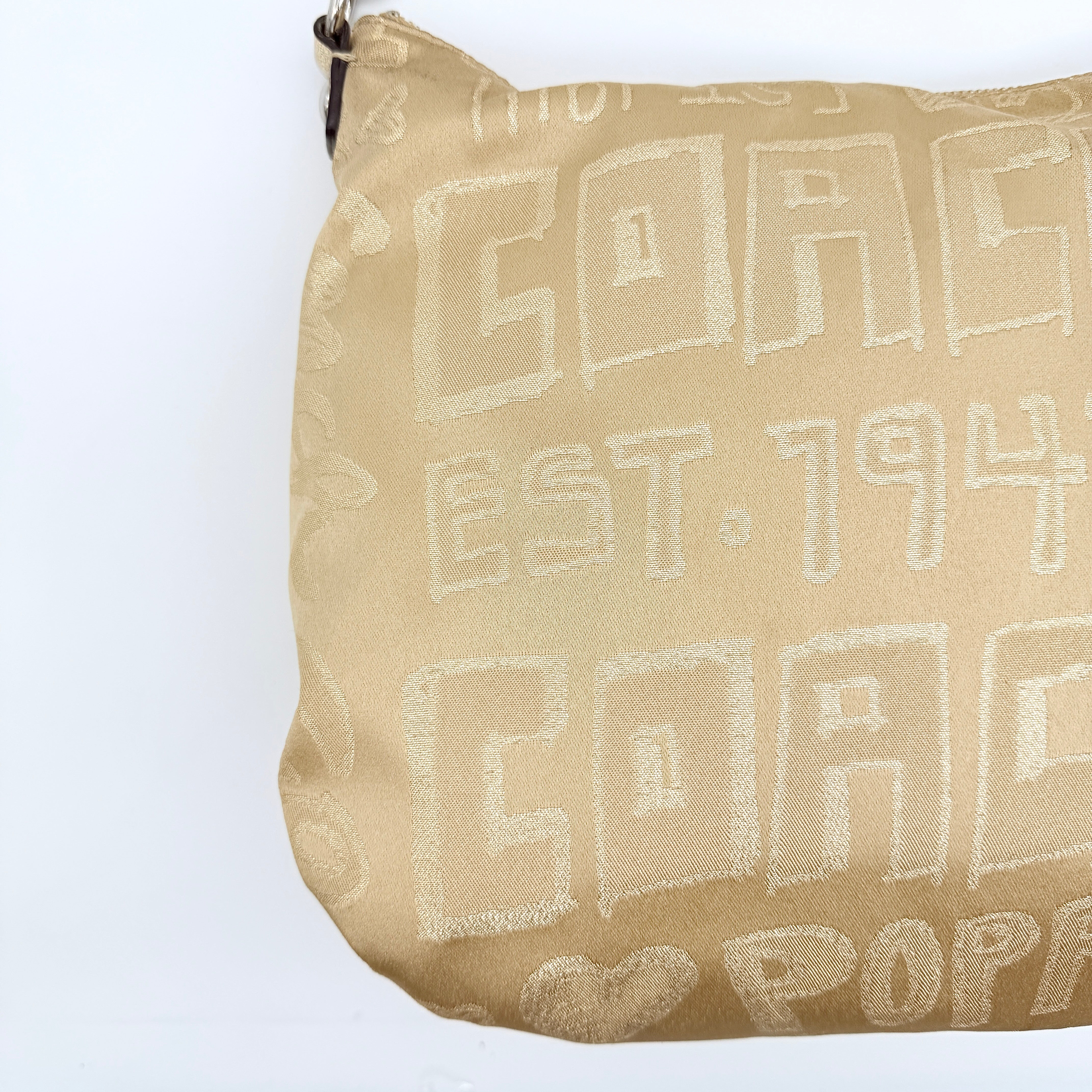 Coach Signature Poppy Pocket Hobo in beige sateen with metallic gold trim and silver hardware, shown with detachable strap.