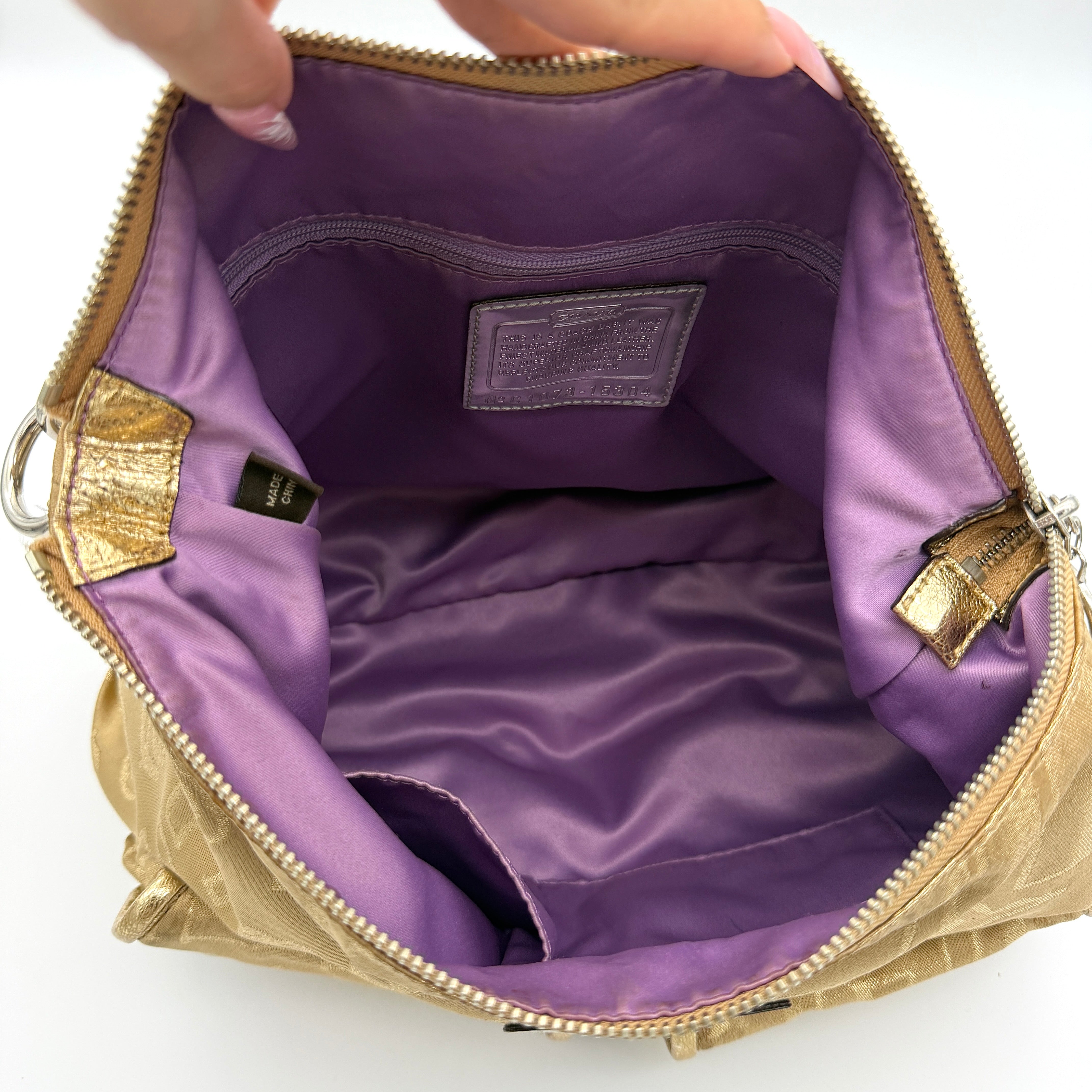 Coach Signature Poppy Pocket Hobo in beige sateen with metallic gold trim and silver hardware, shown with detachable strap.