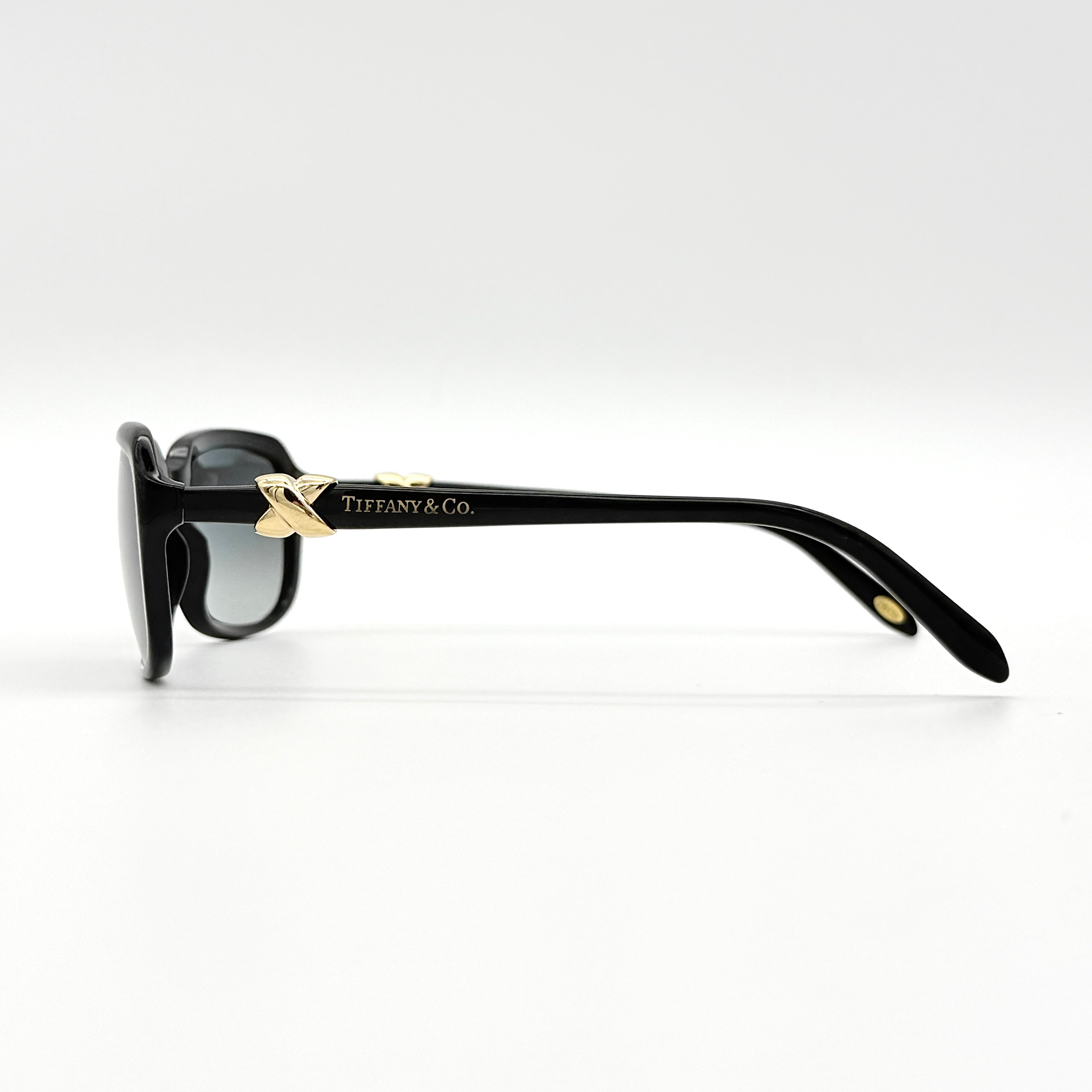 Tiffany & Co. TF4023 sunglasses in black with gold hardware, displayed with original turquoise case and accessories.