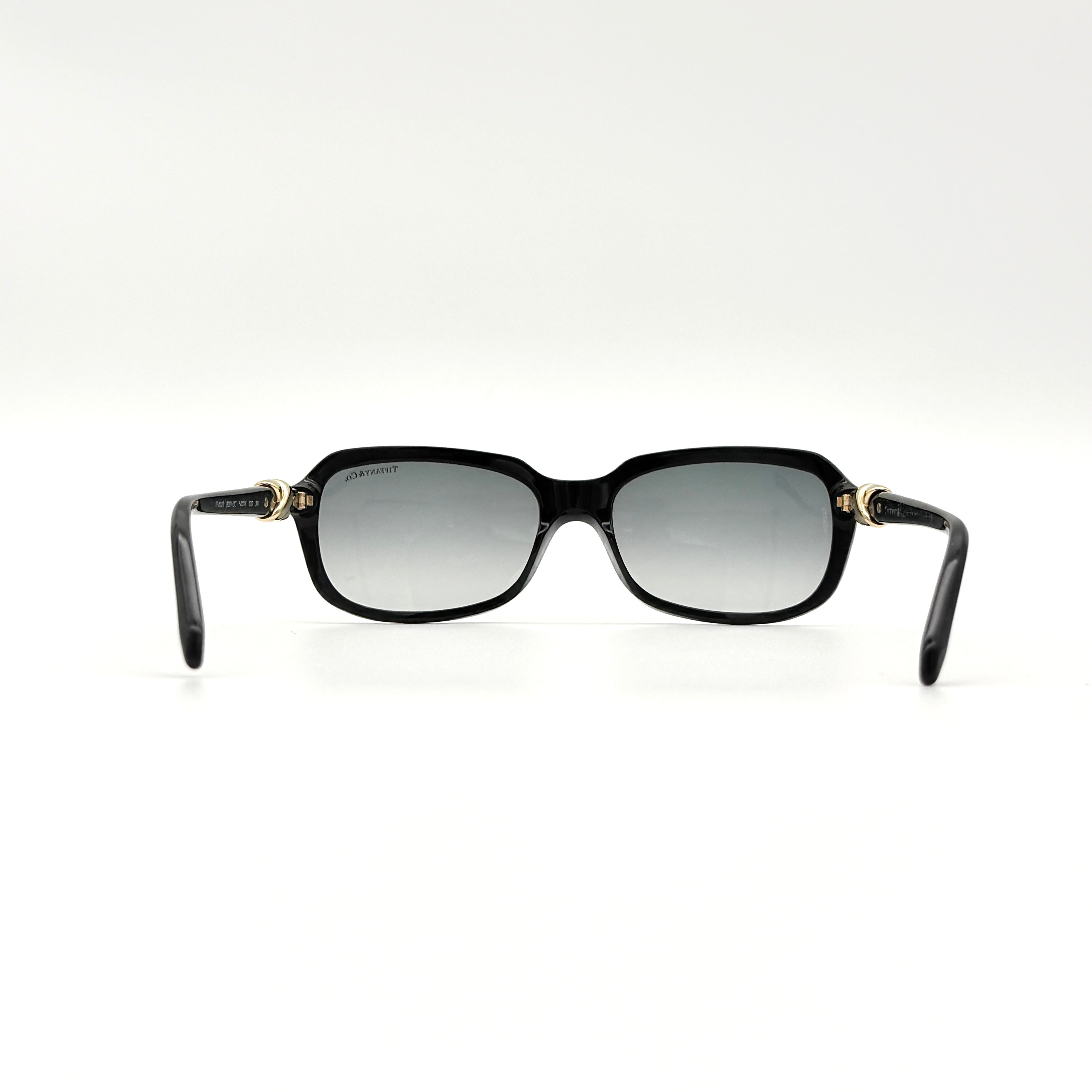 Tiffany & Co. TF4023 sunglasses in black with gold hardware, displayed with original turquoise case and accessories.