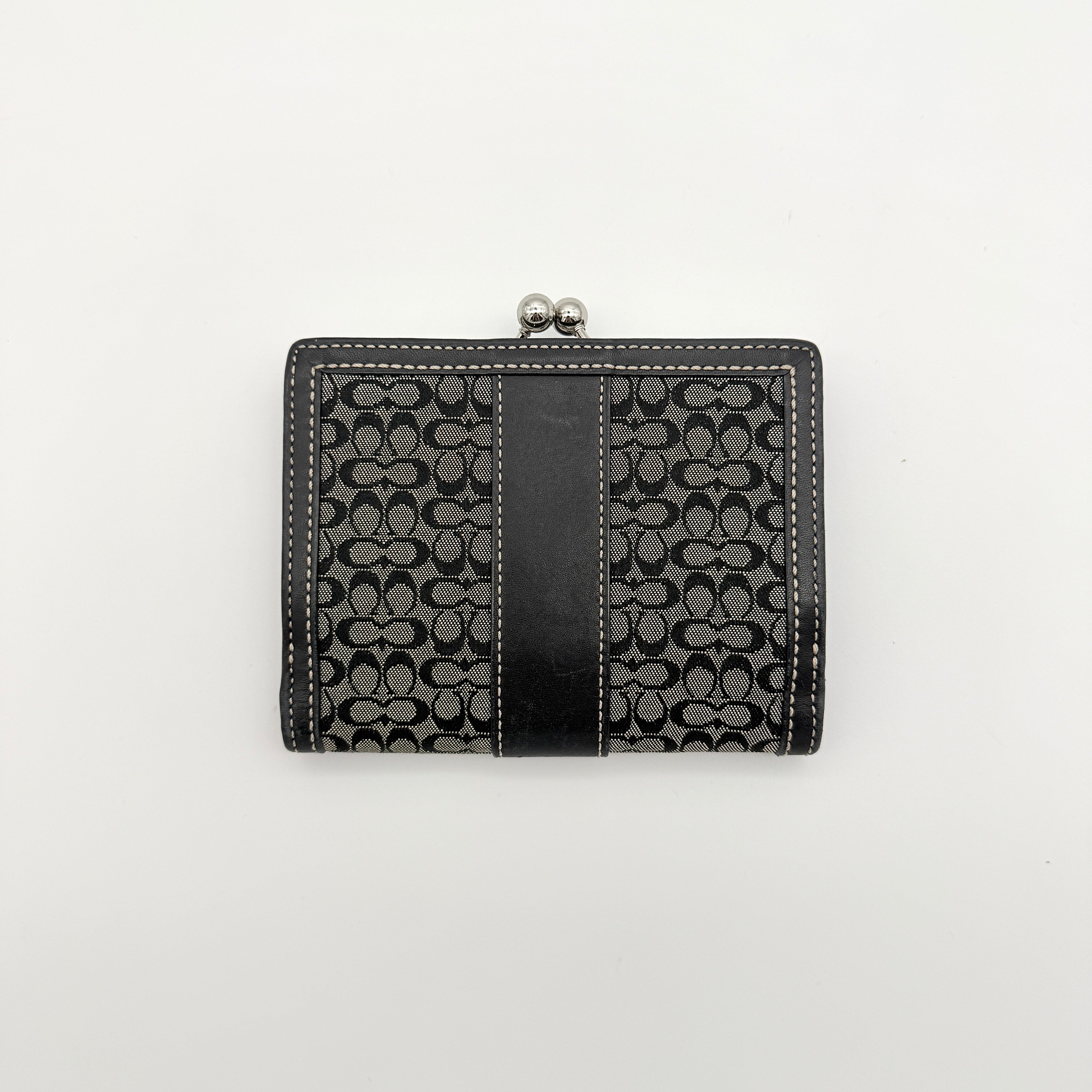 Coach Signature Stripe Kisslock Wallet in grey and black jacquard with black leather trim and silver-tone hardware, shown closed.