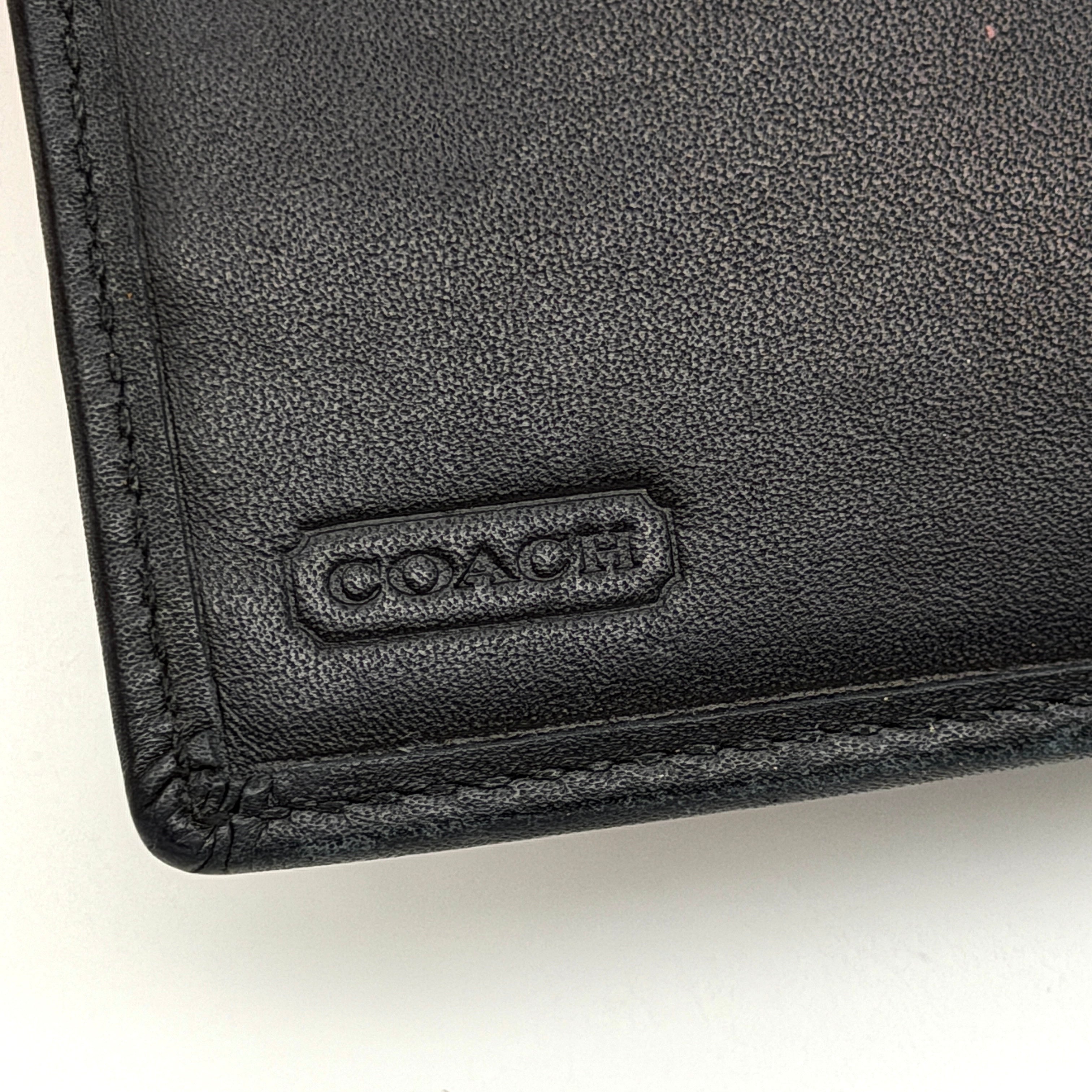 Coach Signature Stripe Kisslock Wallet in grey and black jacquard with black leather trim and silver-tone hardware, shown closed.