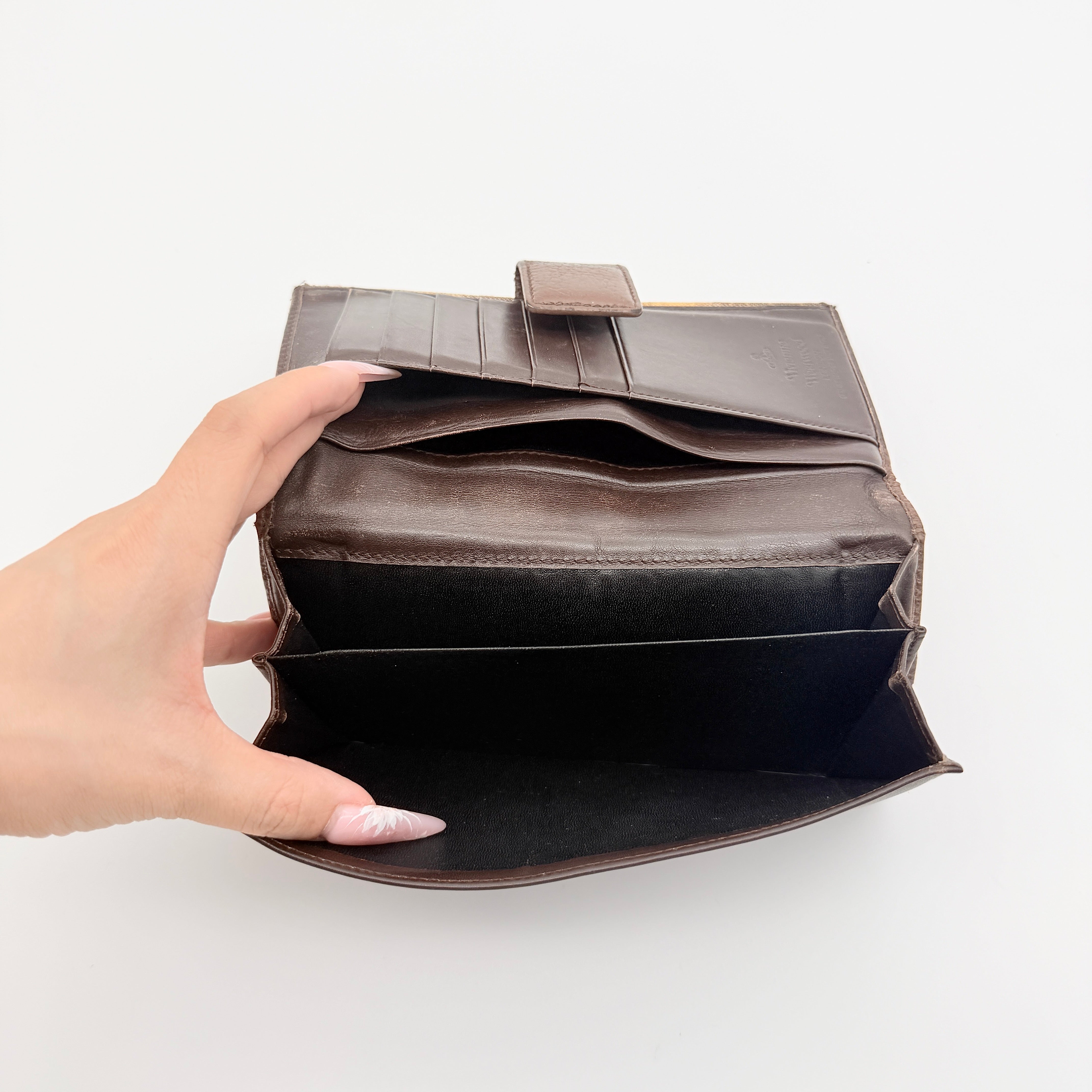 Vivienne Westwood Orb long wallet in beige and brown canvas with the signature Orb logo and leather trim, photographed on a white background.