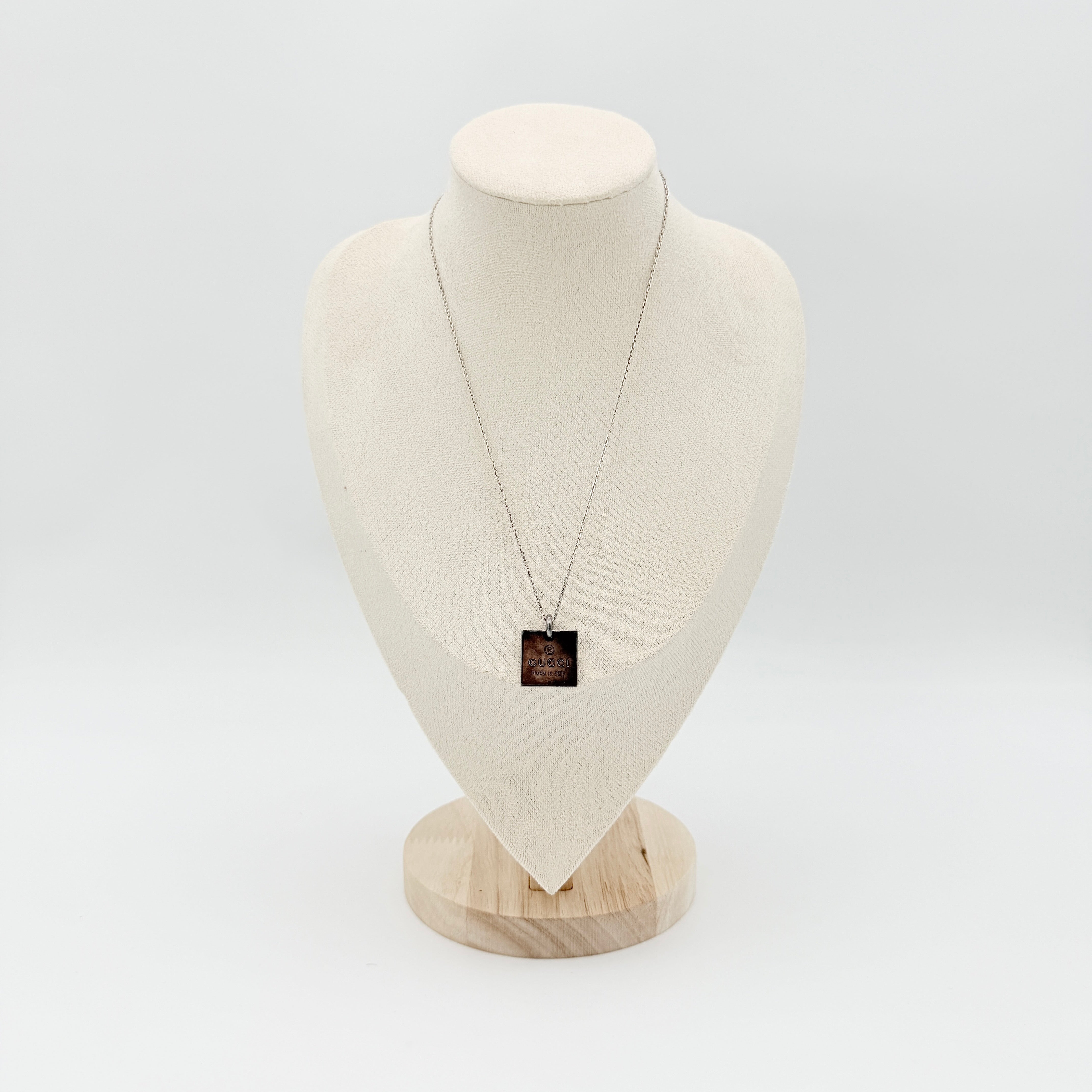 Gucci Trademark Square Plate Necklace in 925 silver with an engraved pendant and fine chain, artfully displayed against a clean background.