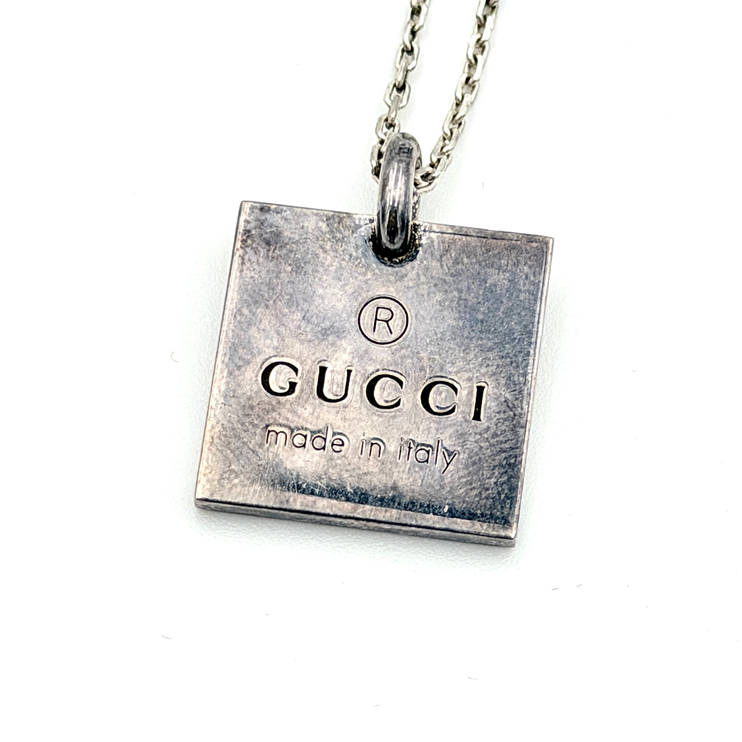 Gucci Trademark Square Plate Necklace in 925 silver with an engraved pendant and fine chain, artfully displayed against a clean background.