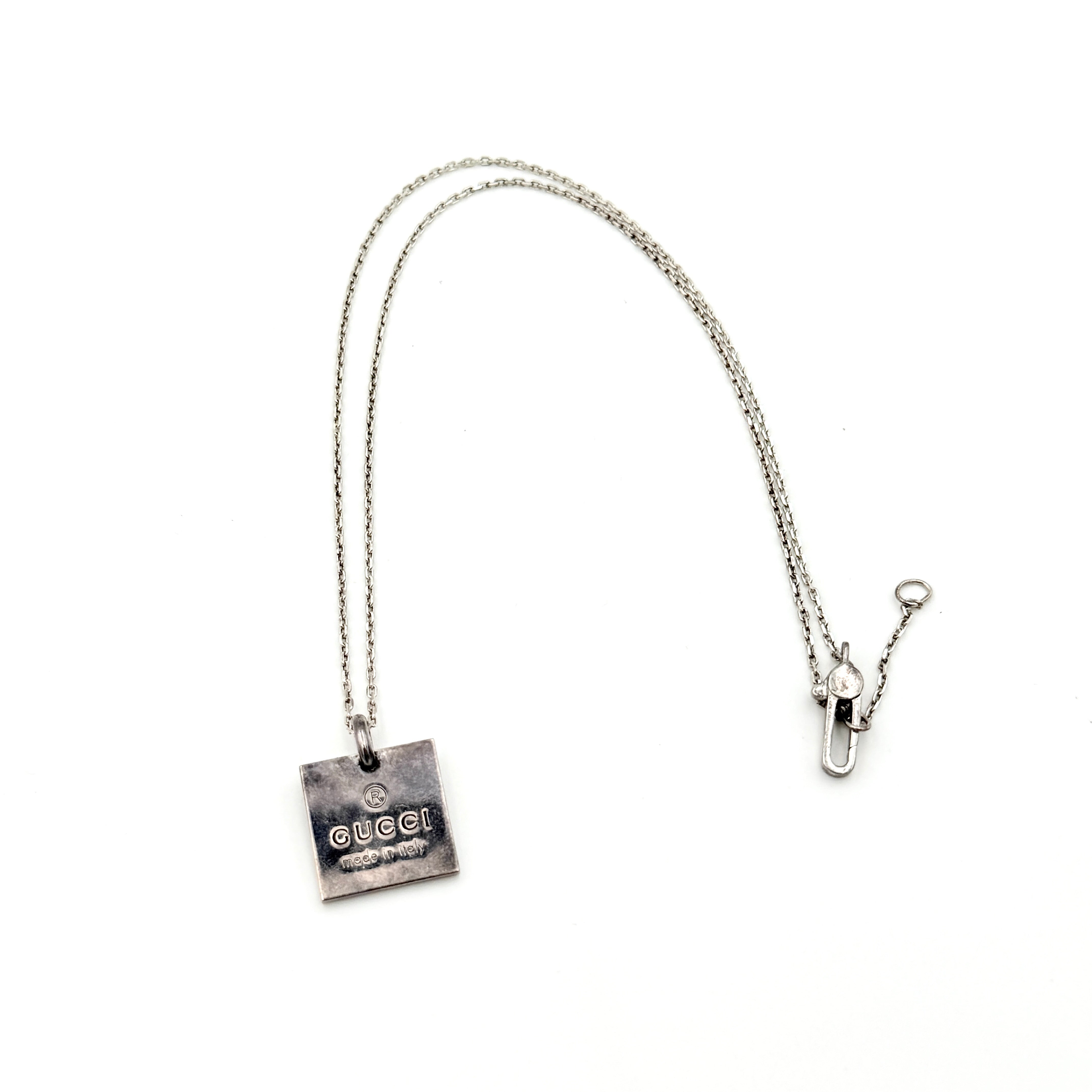 Gucci Trademark Square Plate Necklace in 925 silver with an engraved pendant and fine chain, artfully displayed against a clean background.