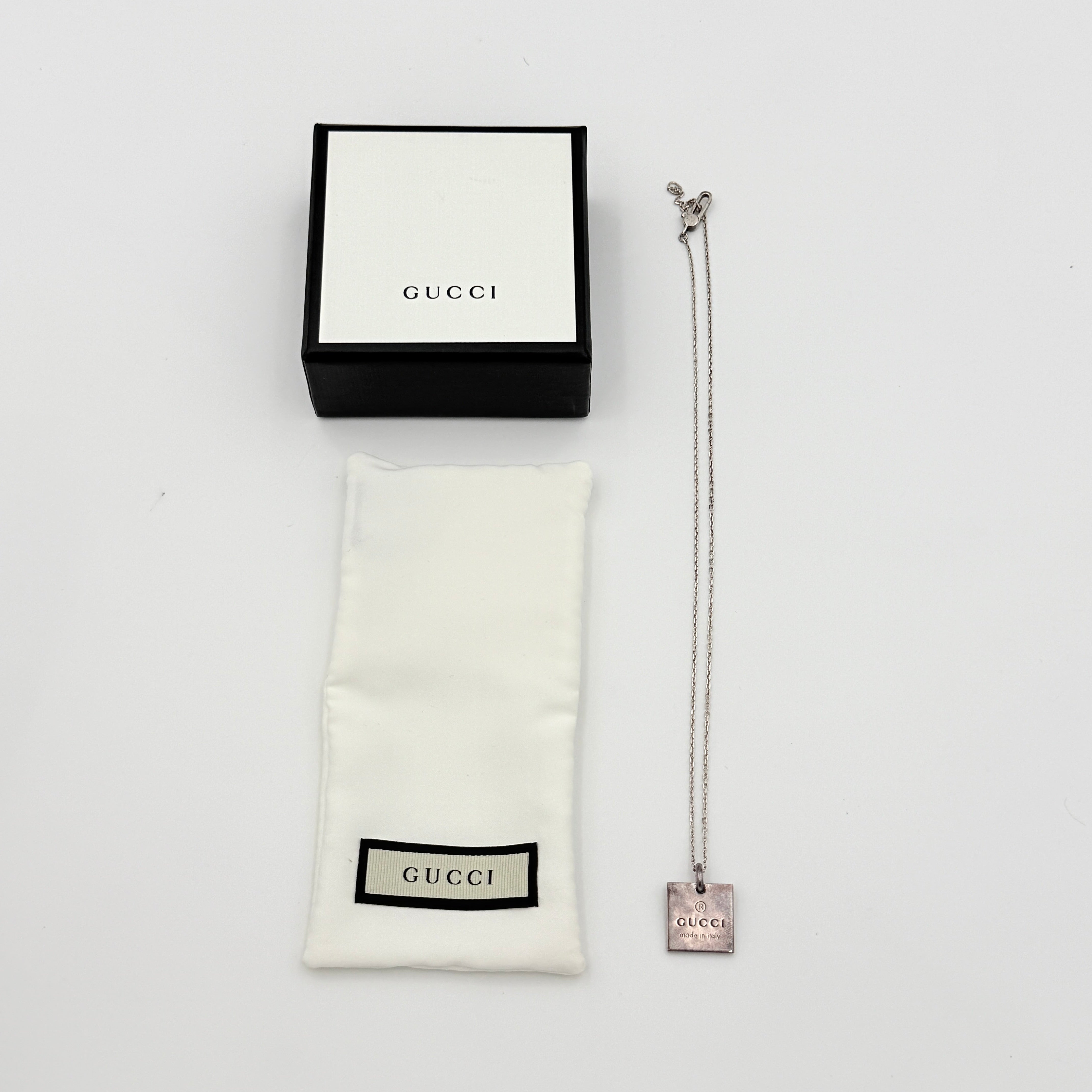 Gucci Trademark Square Plate Necklace in 925 silver with an engraved pendant and fine chain, artfully displayed against a clean background.