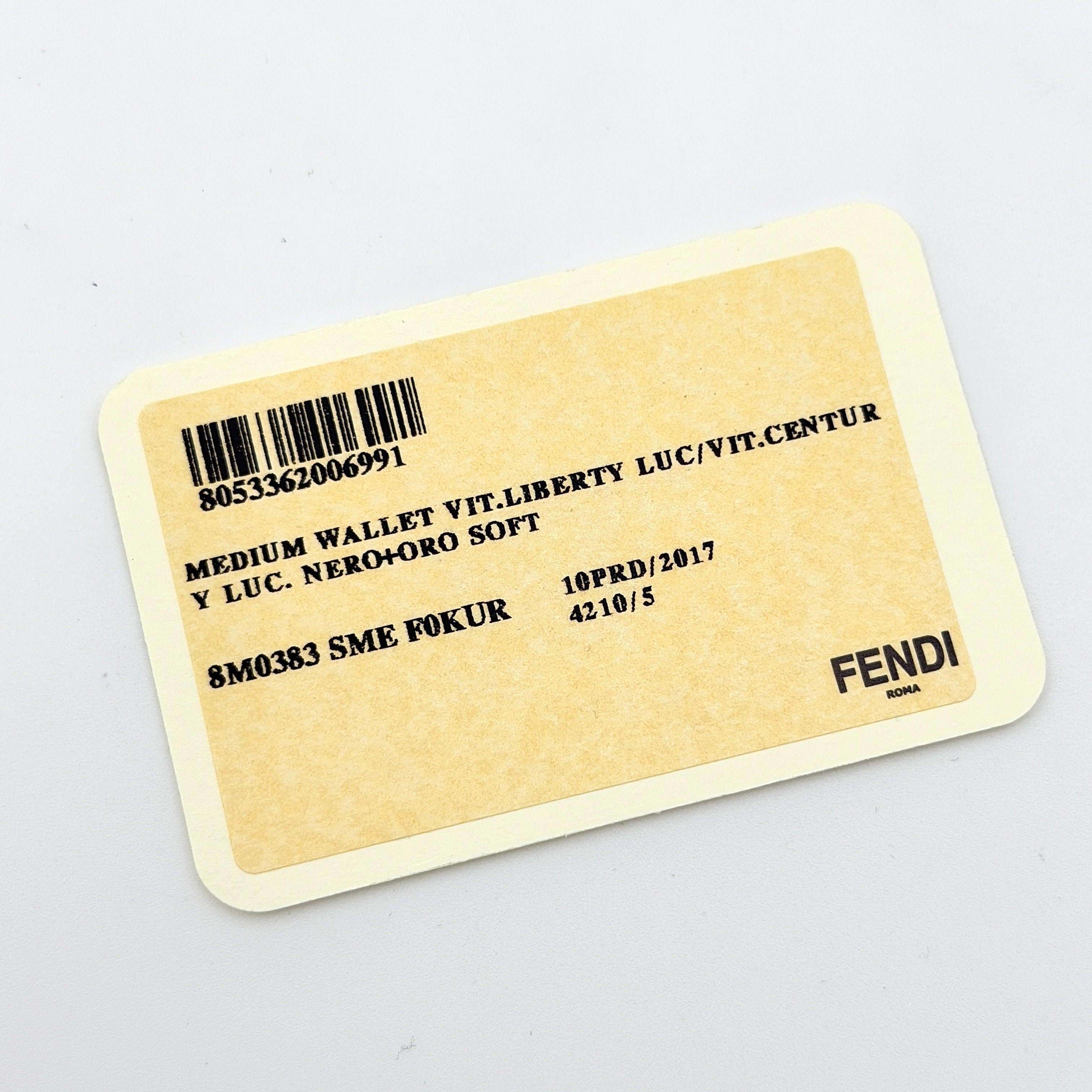 Fendi By The Way Leather Long Wallet in black with gold-tone disc and ring detail on the front flap.
