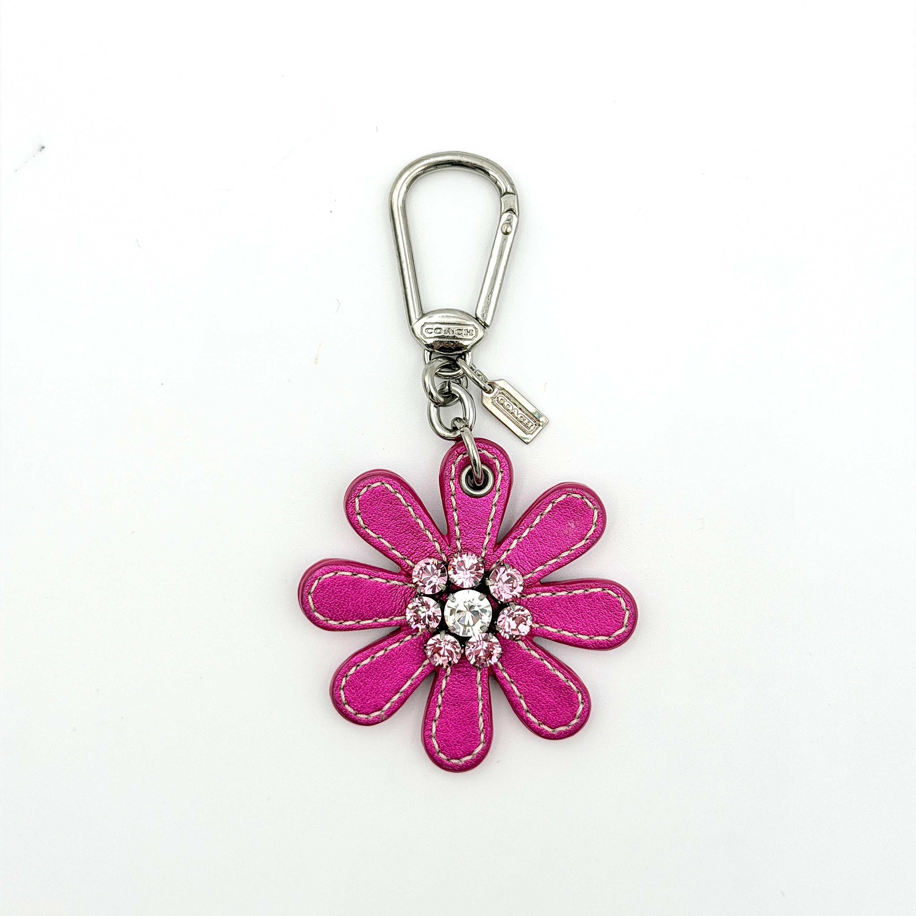 Coach Daisy Flow Bag Charm in magenta leather, featuring crystal accents and silver-tone hardware, styled with precise stitching.