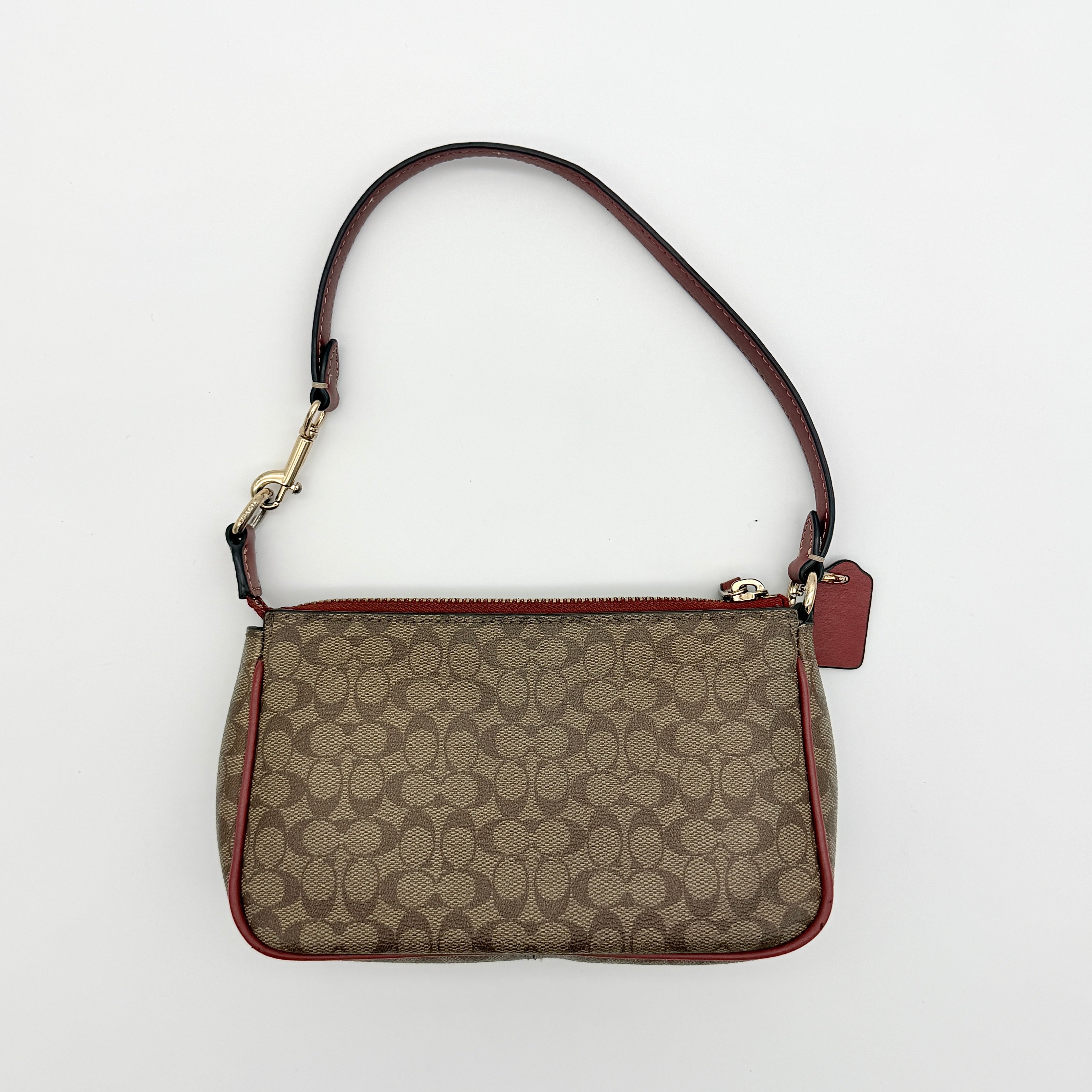 Coach Nolita 19 shoulder bag in beige monogram canvas with red leather trim and gold hardware, top view with strap.