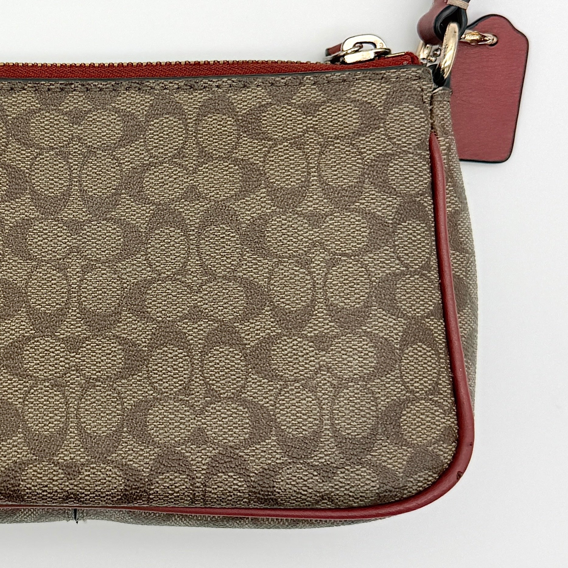 Coach Nolita 19 shoulder bag in beige monogram canvas with red leather trim and gold hardware, top view with strap.