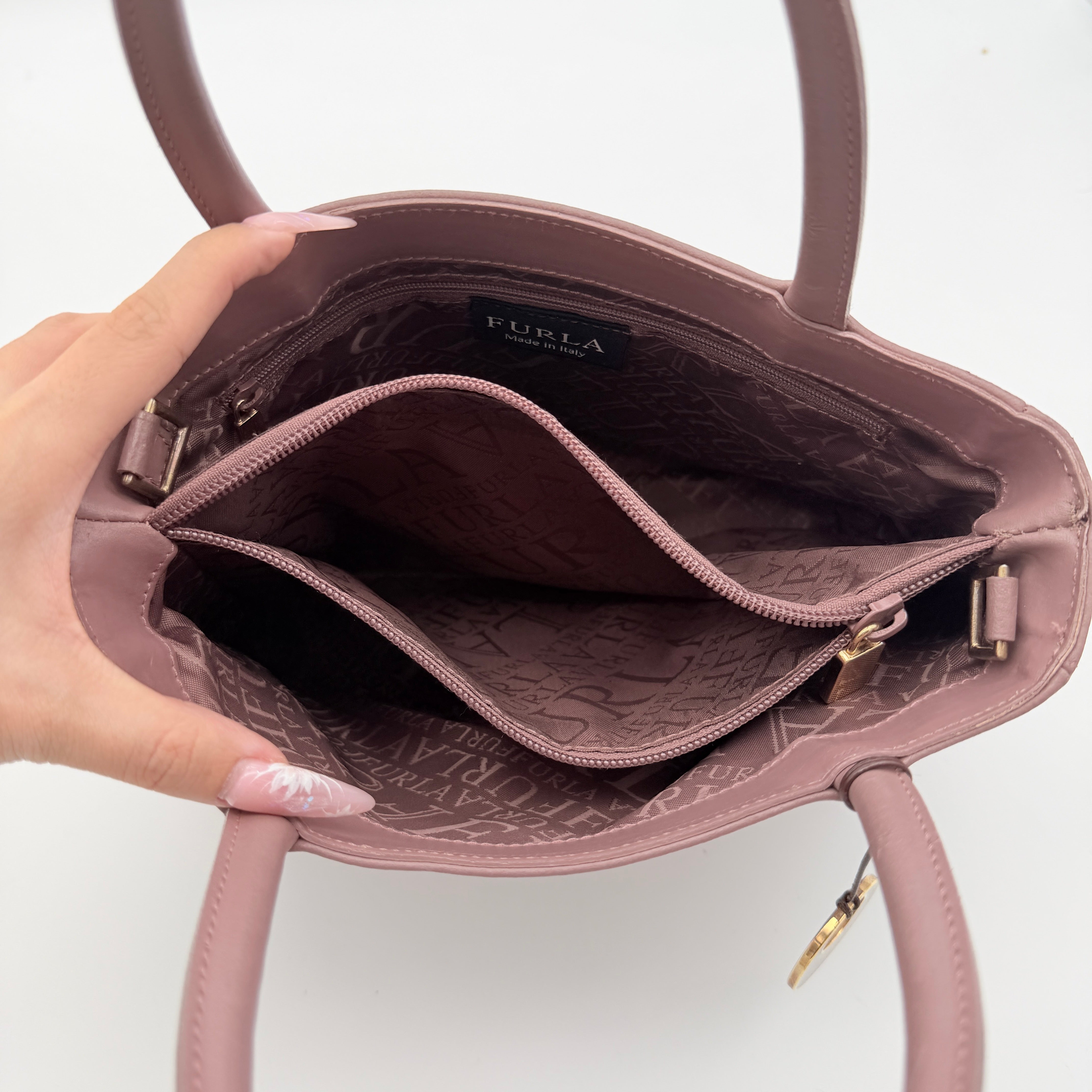 Furla 2Way Leather Handbag in pink with top handles, gold-tone charm, and a detachable strap, photographed on a white background.
