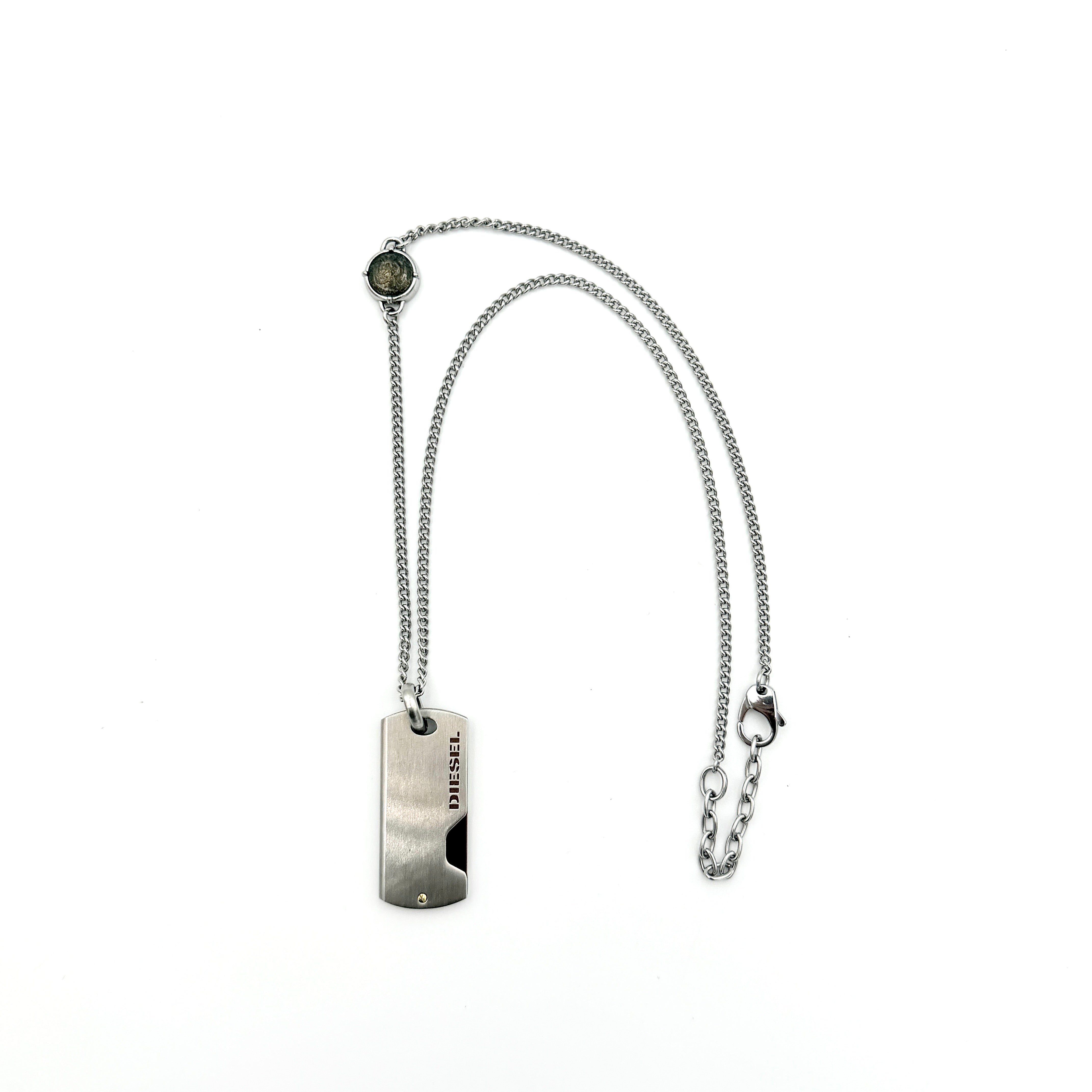 Diesel silver-tone stainless steel dog tag necklace with bronze accent, curb chain, and round detail showcased on a white background.