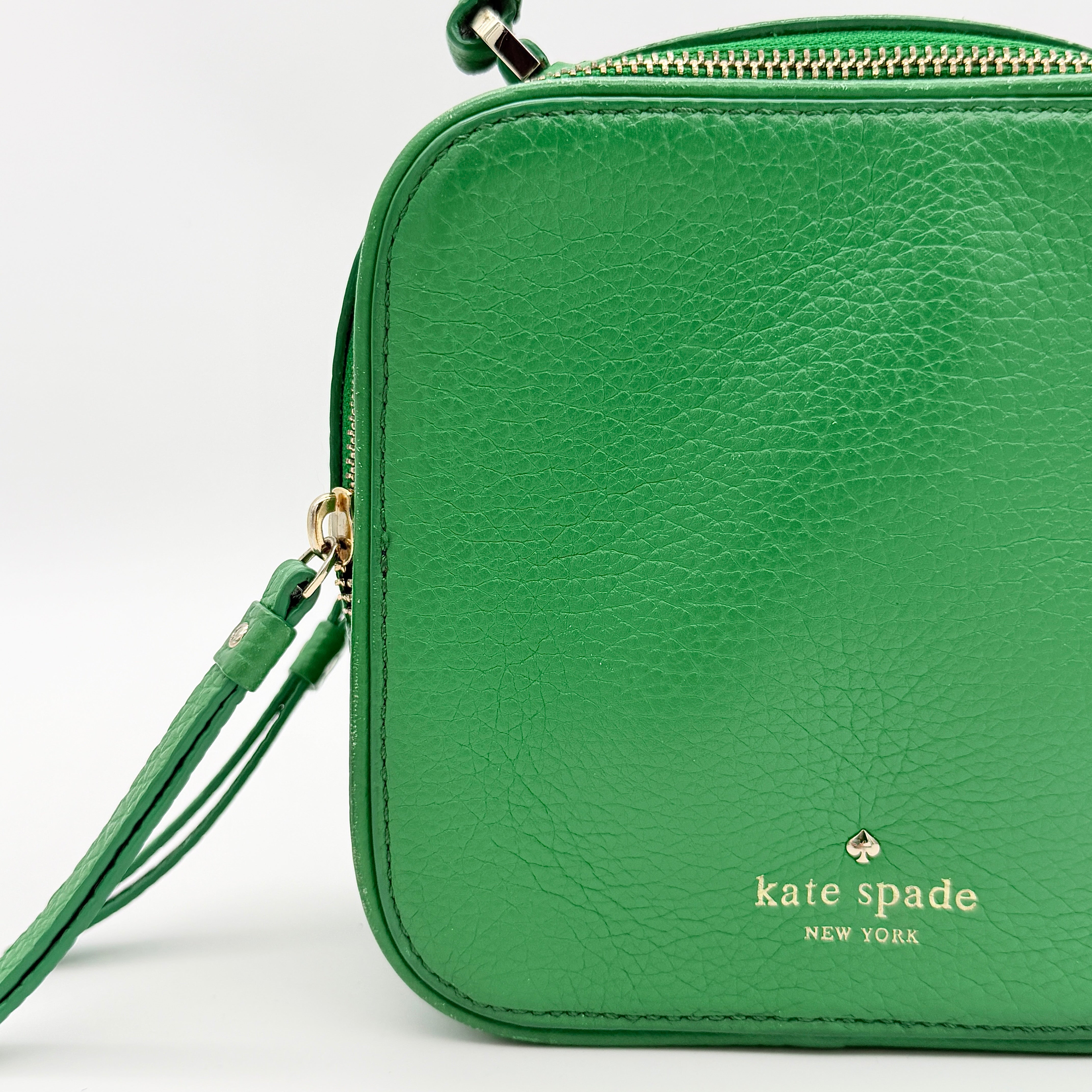 Kate Spade 2Way Vanity Crossbody Bag in bright green pebbled leather with top handle and detachable strap displayed in studio lighting.