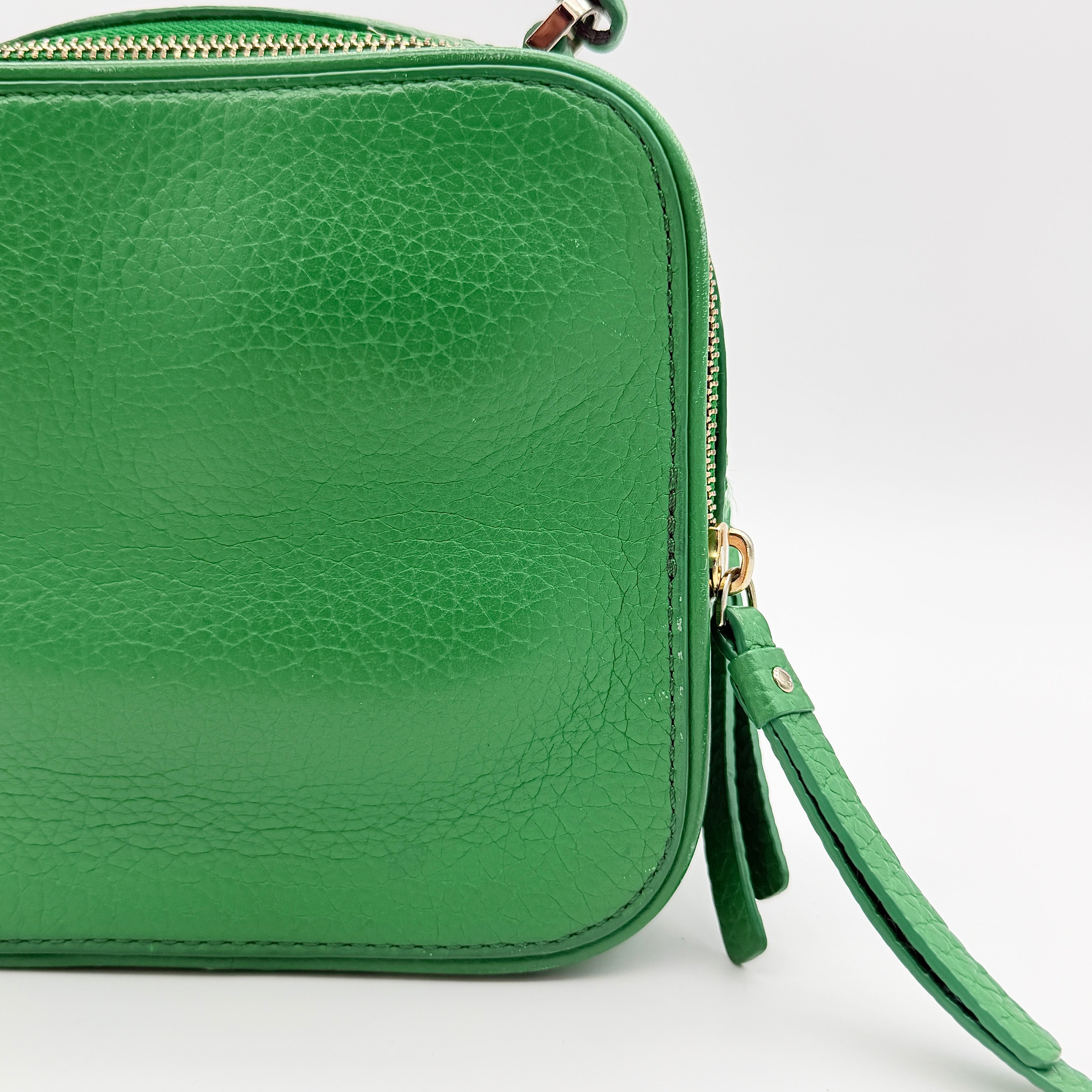 Kate Spade 2Way Vanity Crossbody Bag in bright green pebbled leather with top handle and detachable strap displayed in studio lighting.