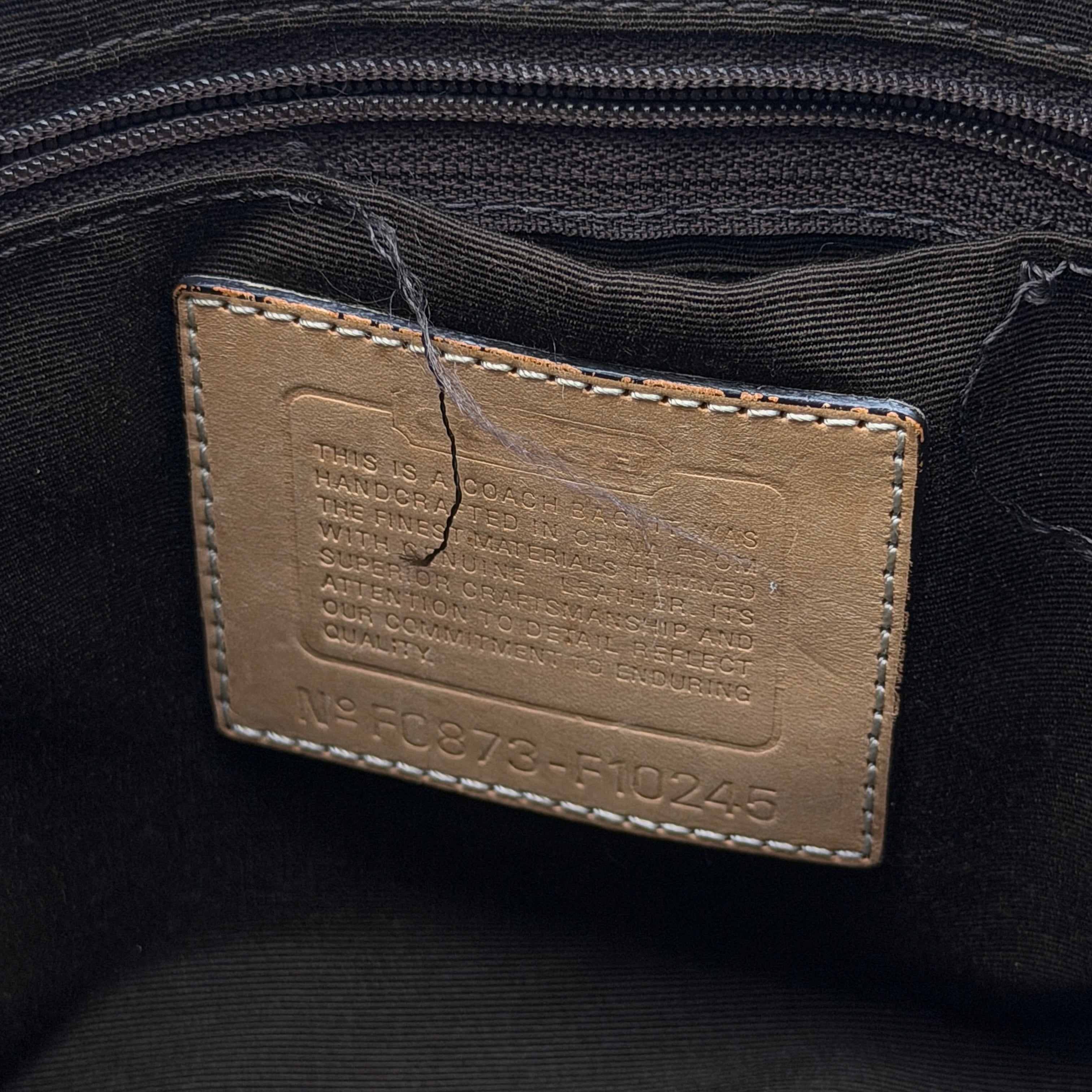 Coach Signature Hampton Carryall shoulder bag in beige monogram canvas and tan leather with silver-tone hardware and double handles.