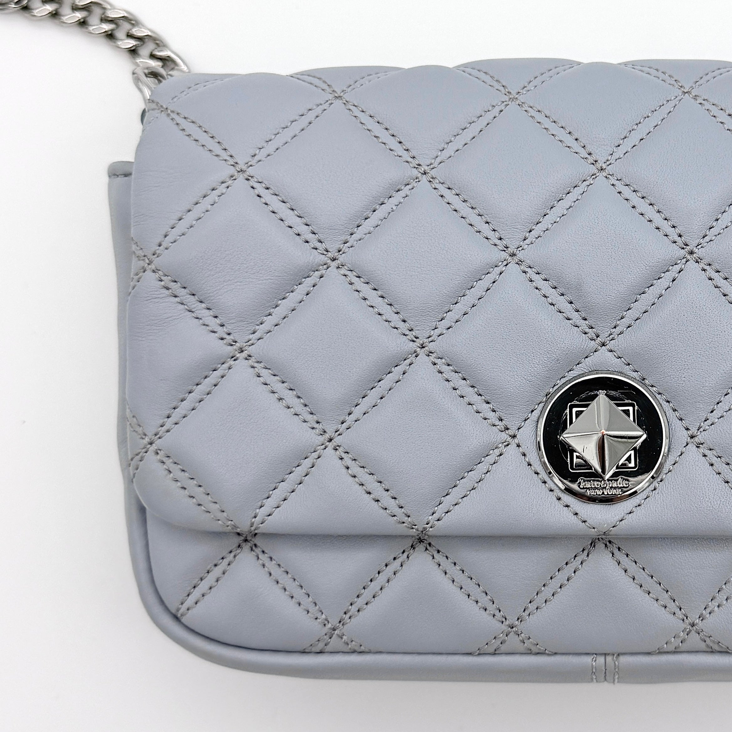 Kate Spade Natalia Flap Crossbody in light blue quilted leather with a silver chain and turn-lock detail.