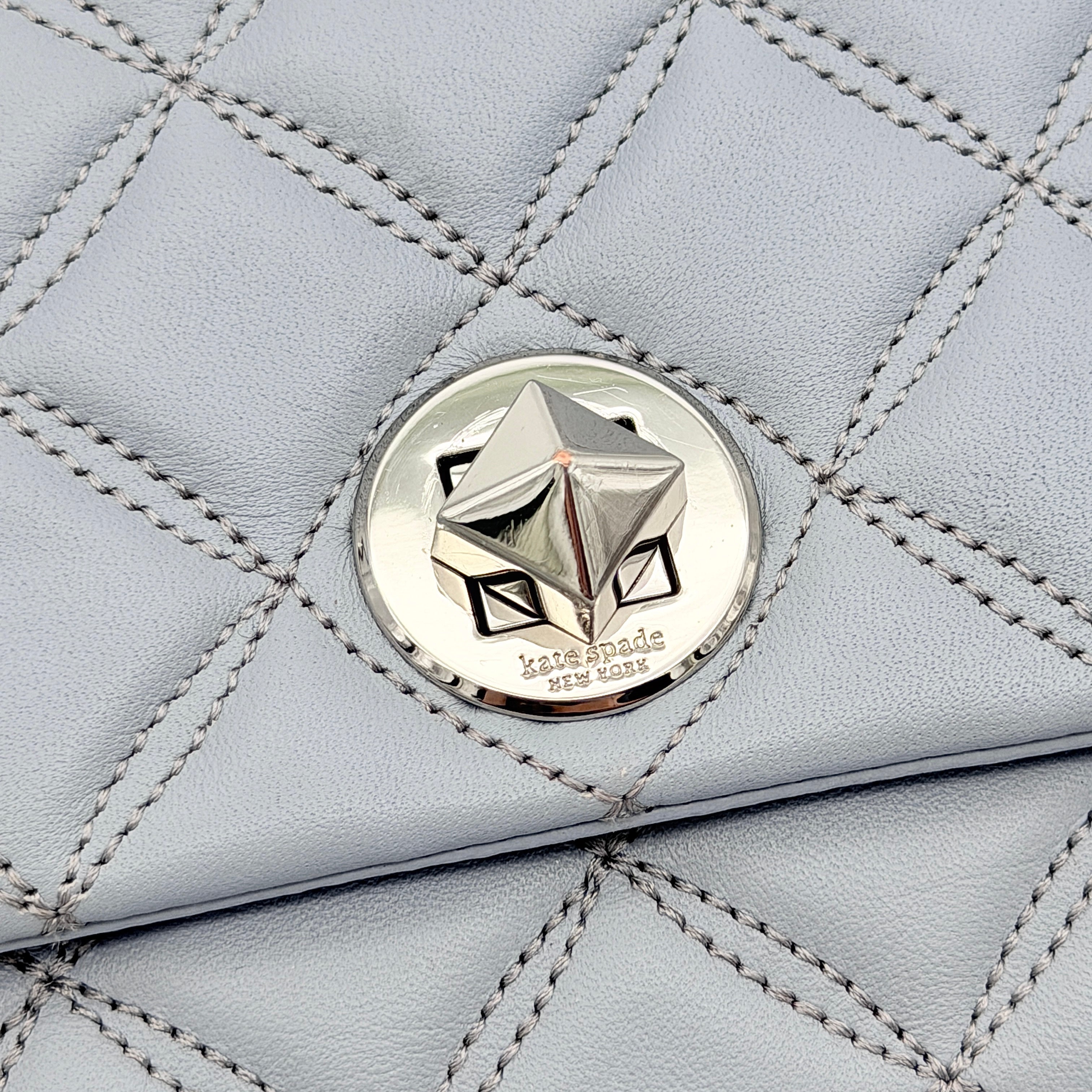 Kate Spade Natalia Flap Crossbody in light blue quilted leather with a silver chain and turn-lock detail.