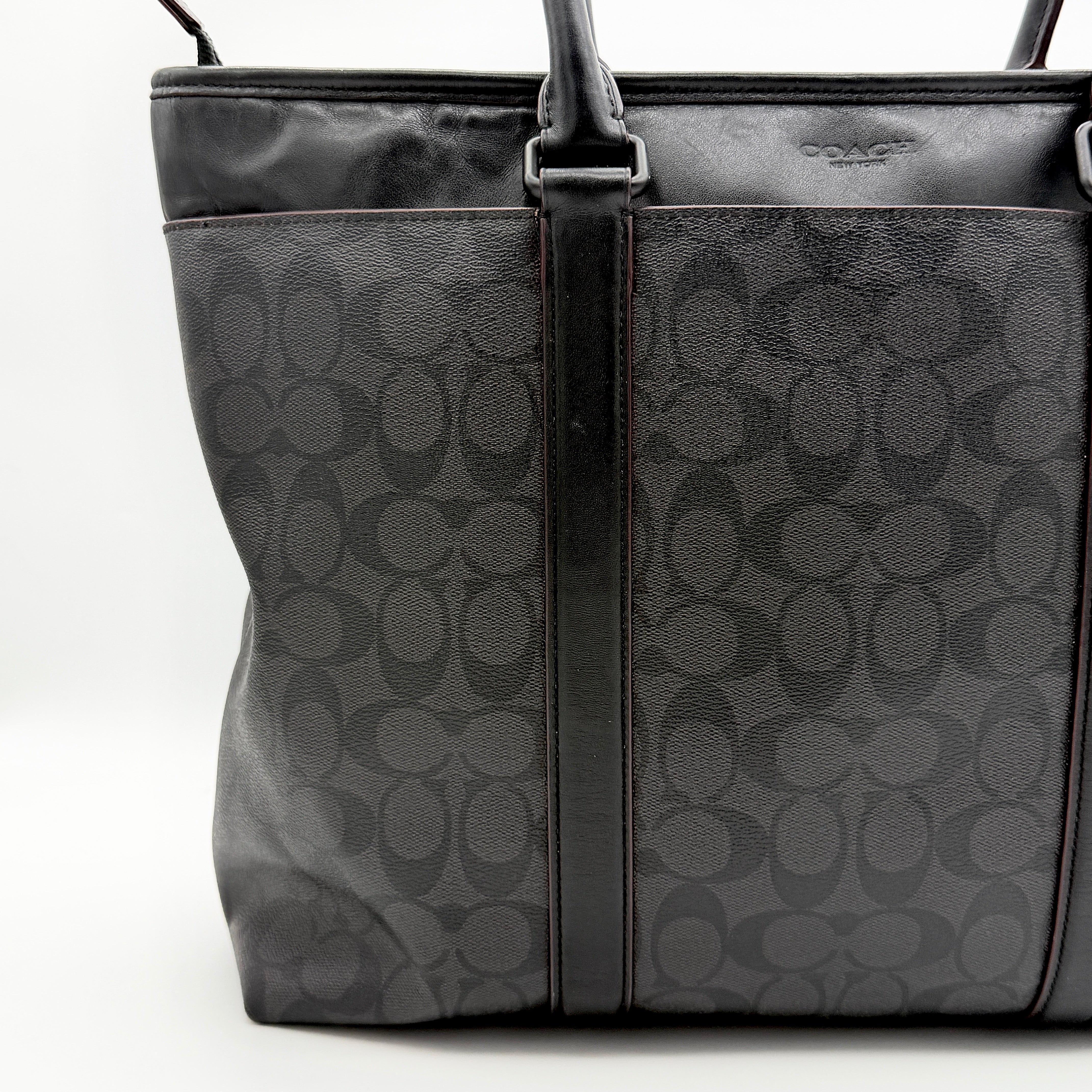 Coach Perry Business Tote in charcoal black signature canvas with double handles and detachable strap, shown upright against a white background.