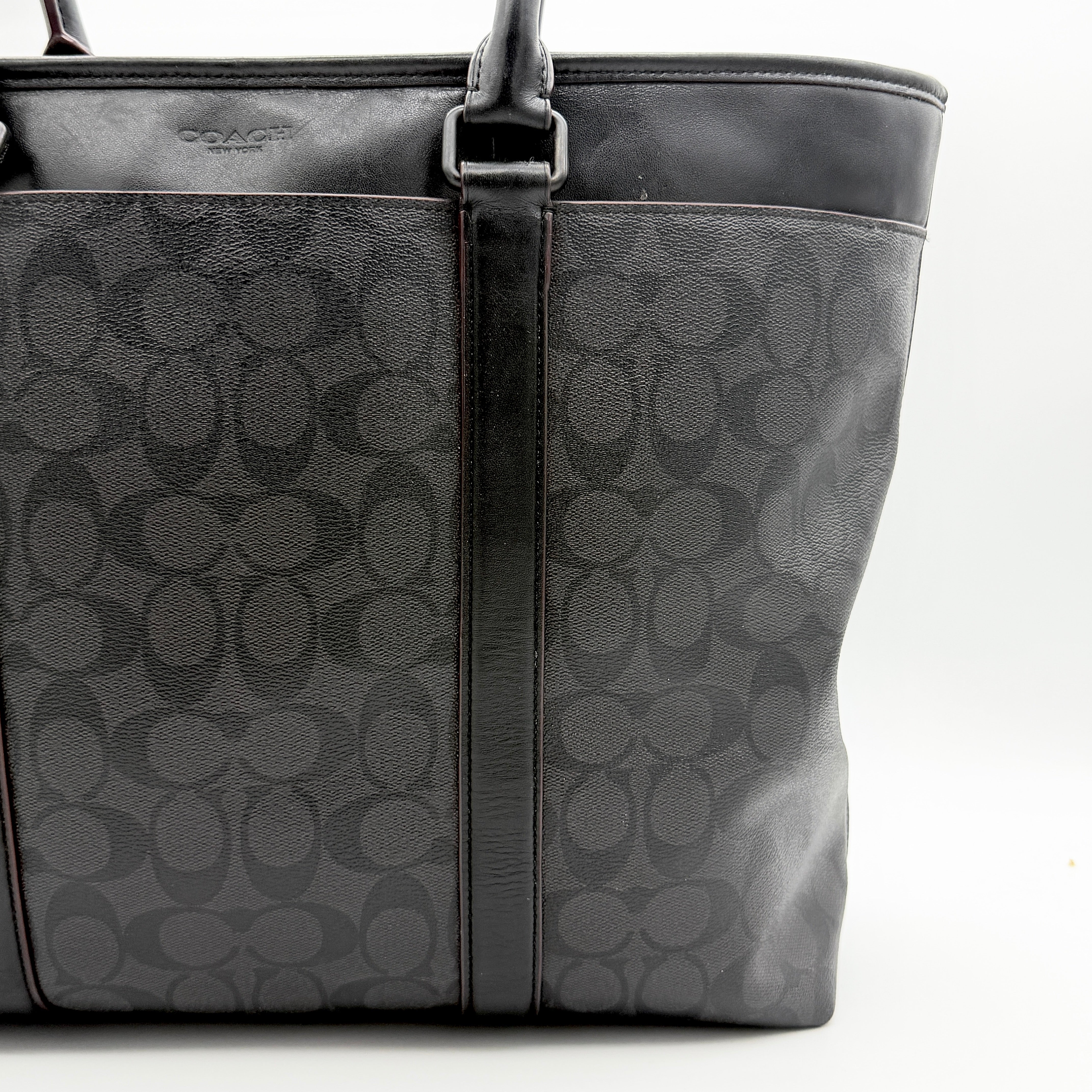 Coach Perry Business Tote in charcoal black signature canvas with double handles and detachable strap, shown upright against a white background.