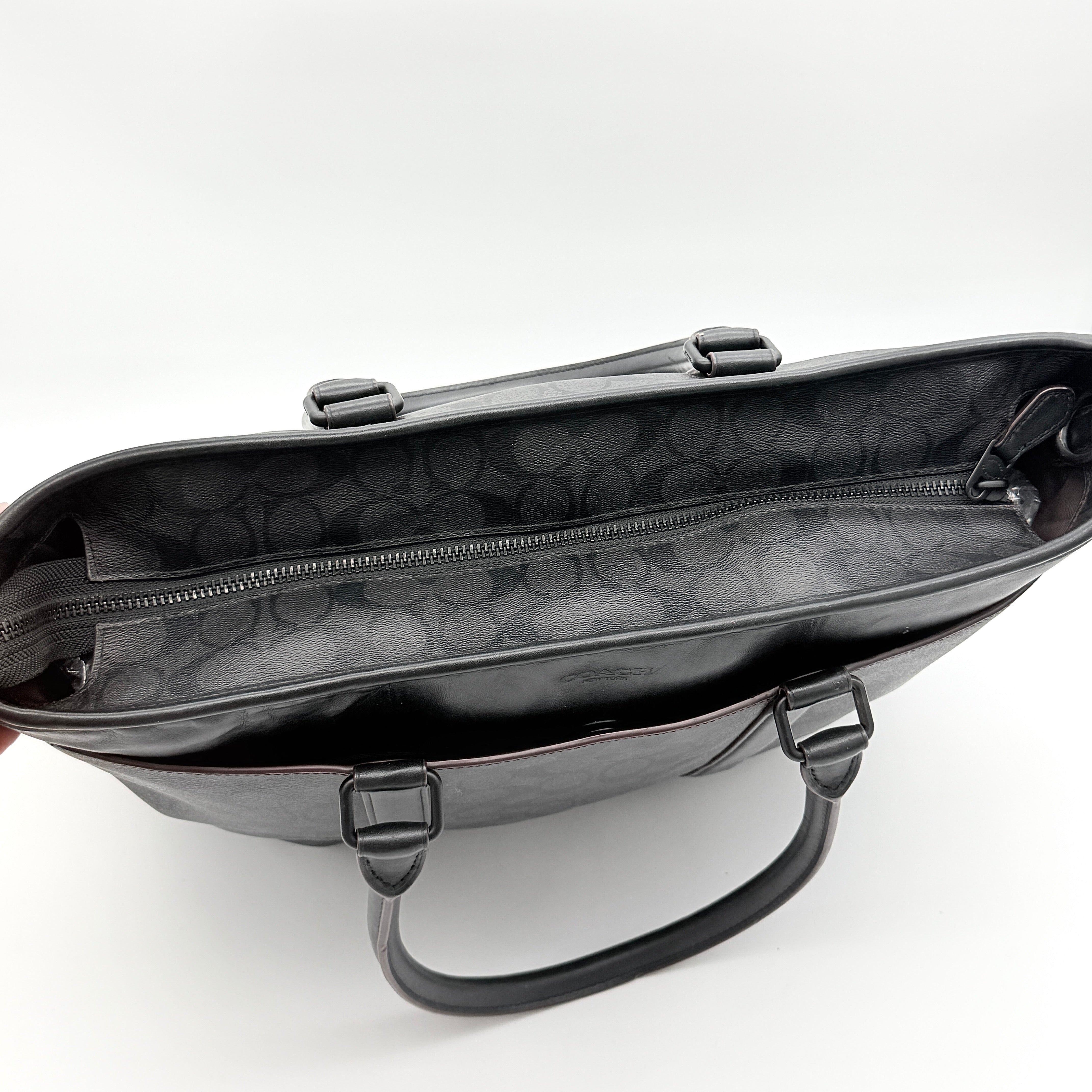 Coach Perry Business Tote in charcoal black signature canvas with double handles and detachable strap, shown upright against a white background.