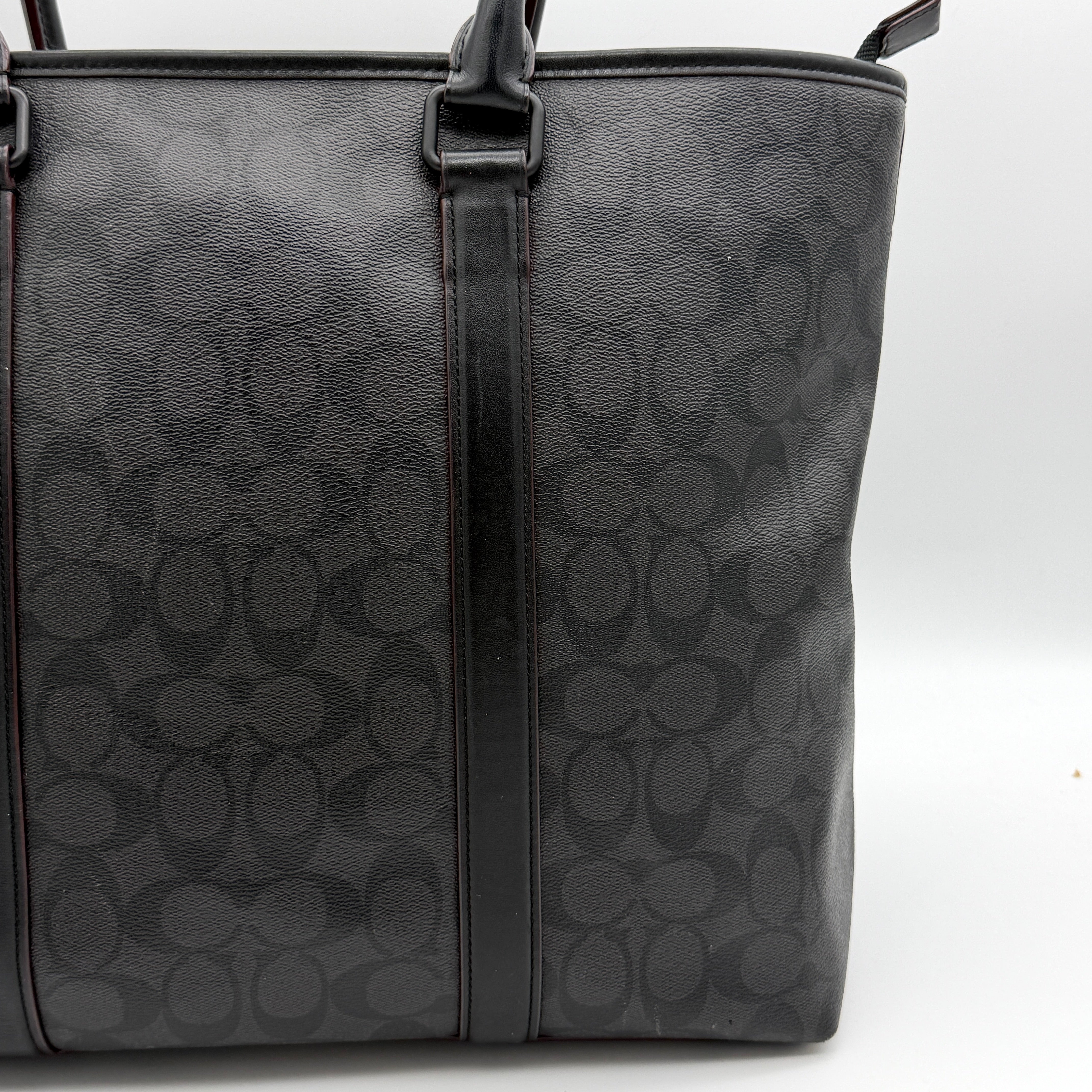 Coach Perry Business Tote in charcoal black signature canvas with double handles and detachable strap, shown upright against a white background.