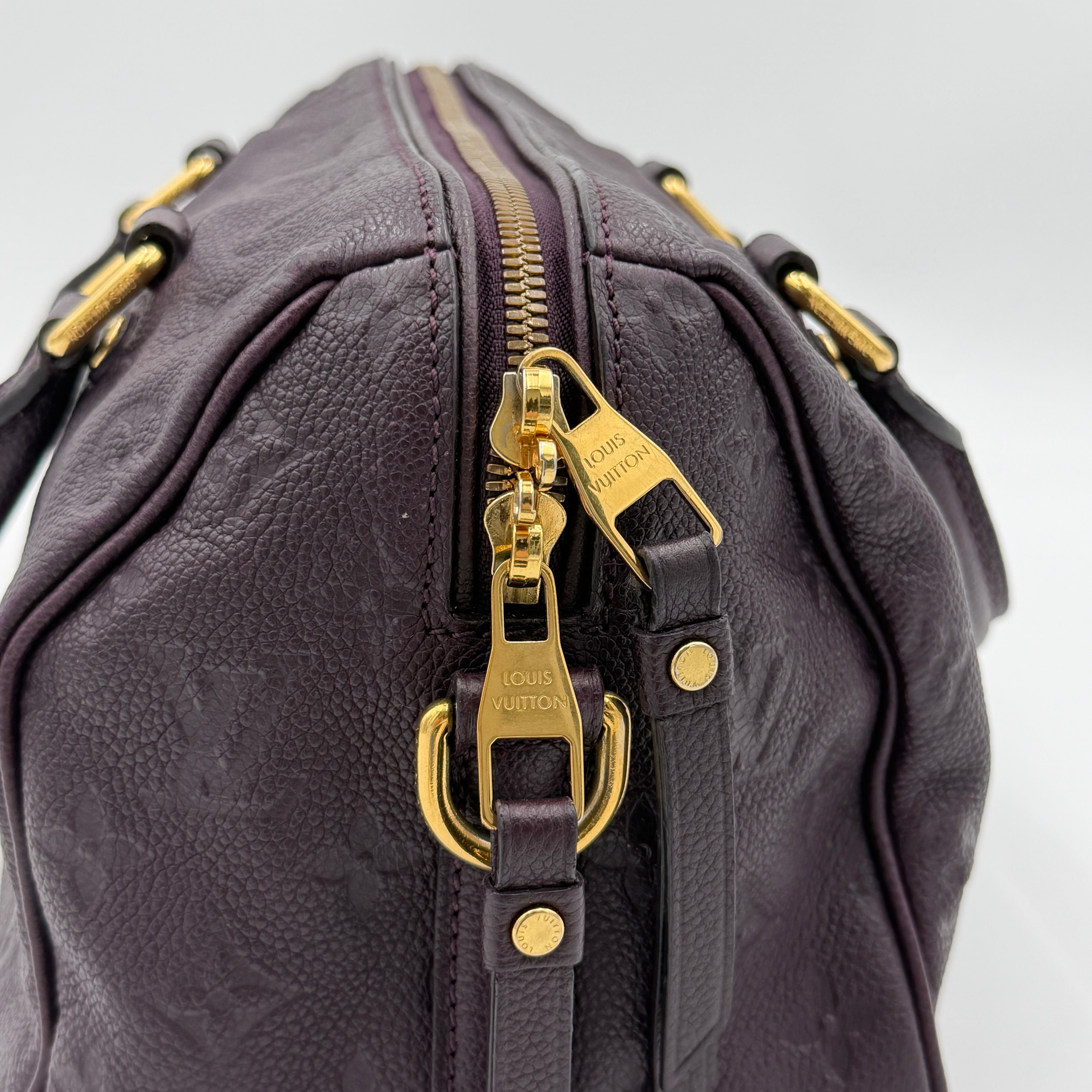 Louis Vuitton 2Way Monogram Empreinte Speedy Bandoulière 25 in deep purple grained leather with gold-tone hardware and detachable strap.