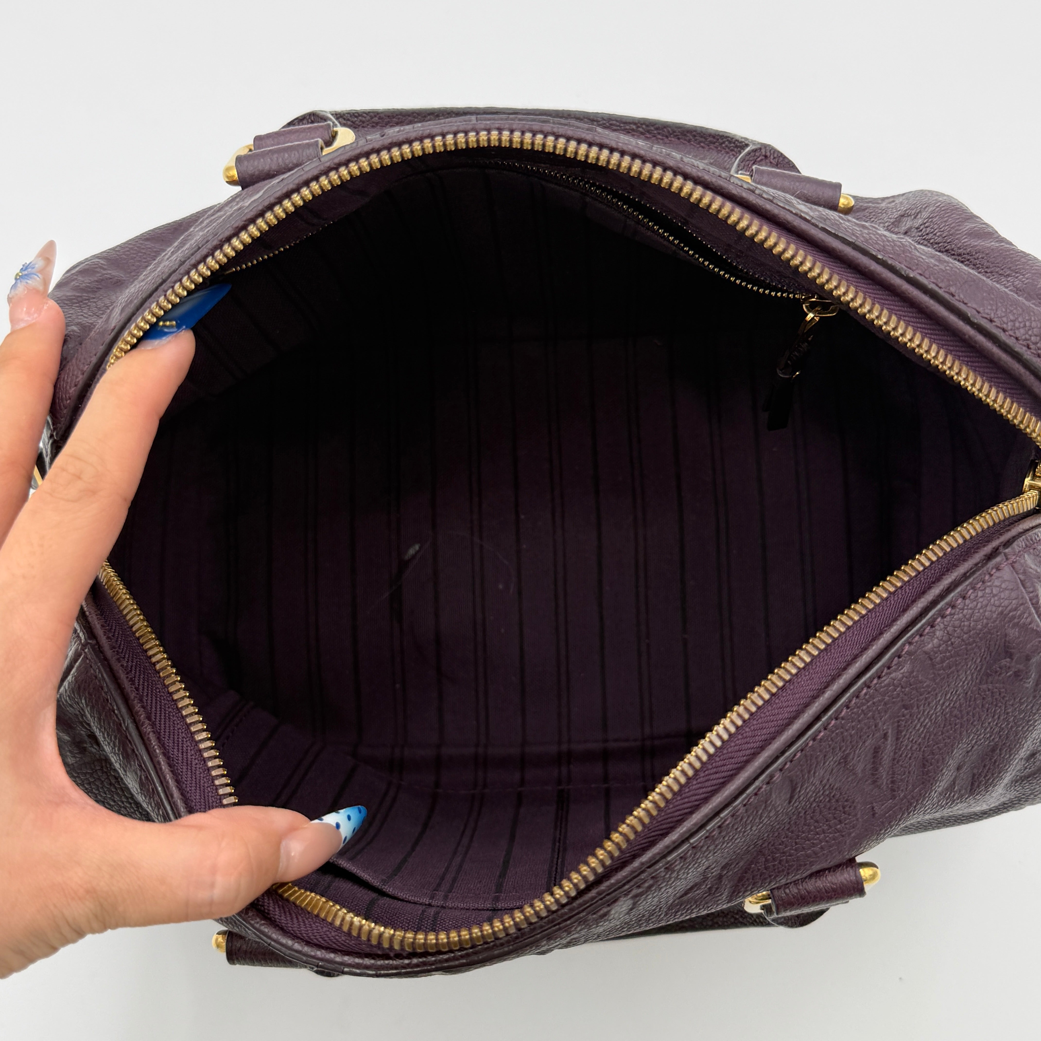 Louis Vuitton 2Way Monogram Empreinte Speedy Bandoulière 25 in deep purple grained leather with gold-tone hardware and detachable strap.