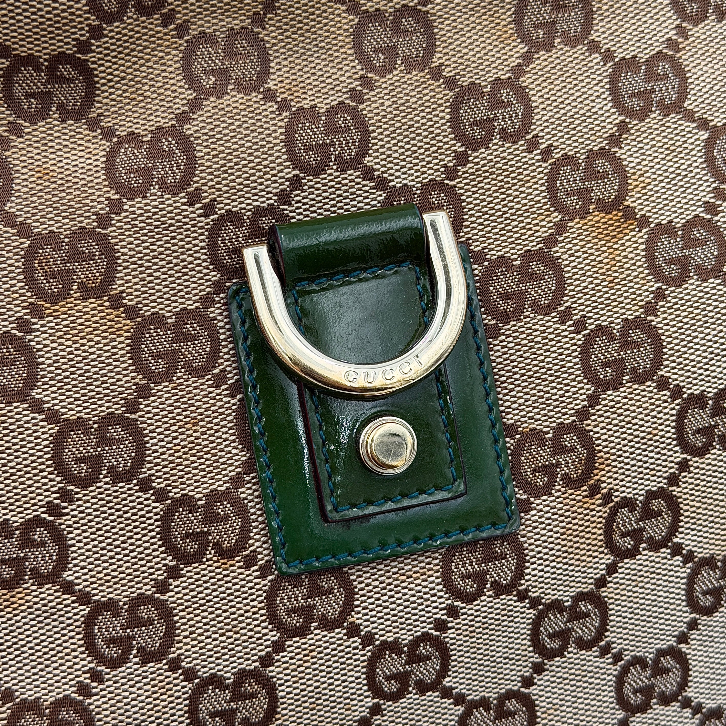 Gucci GG Monogram Abbey D Ring Crossbody Bag in beige canvas with green leather trim and gold-tone hardware, featuring an adjustable green strap.