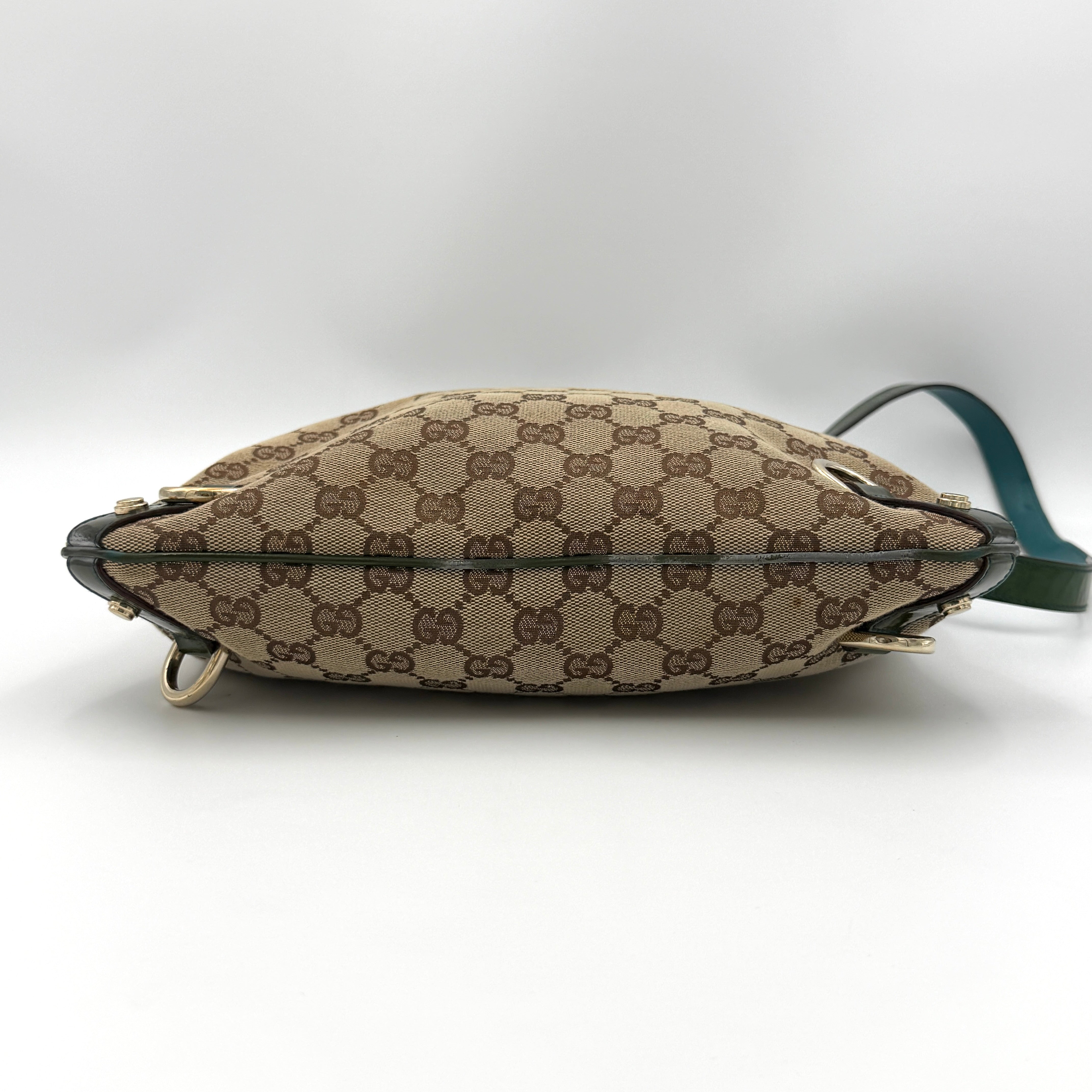 Gucci GG Monogram Abbey D Ring Crossbody Bag in beige canvas with green leather trim and gold-tone hardware, featuring an adjustable green strap.