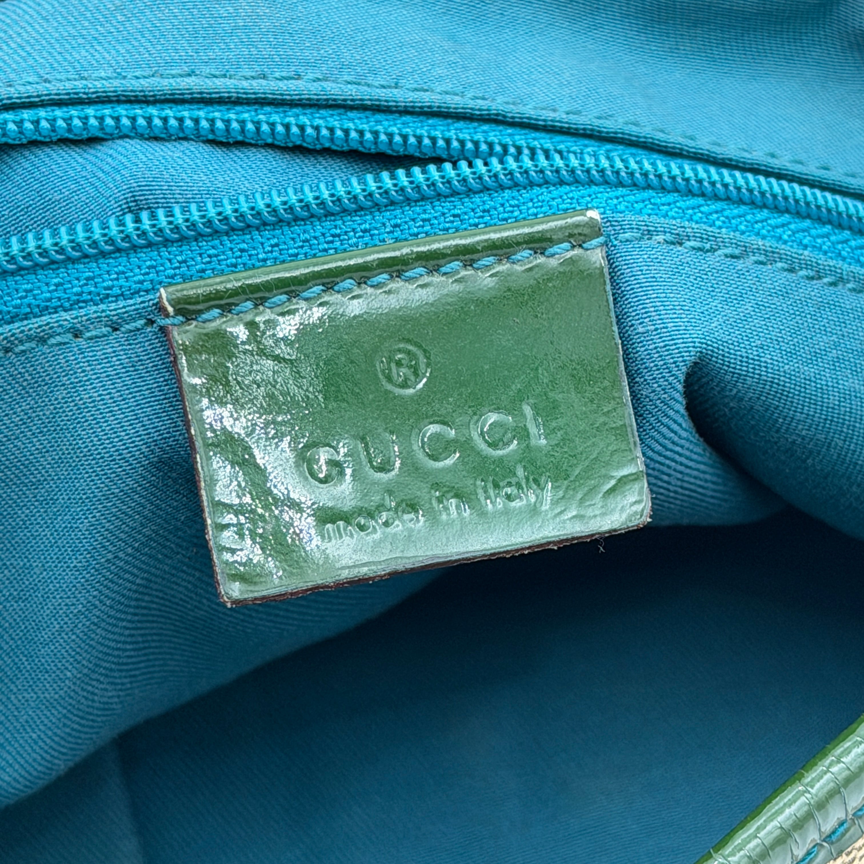 Gucci GG Monogram Abbey D Ring Crossbody Bag in beige canvas with green leather trim and gold-tone hardware, featuring an adjustable green strap.