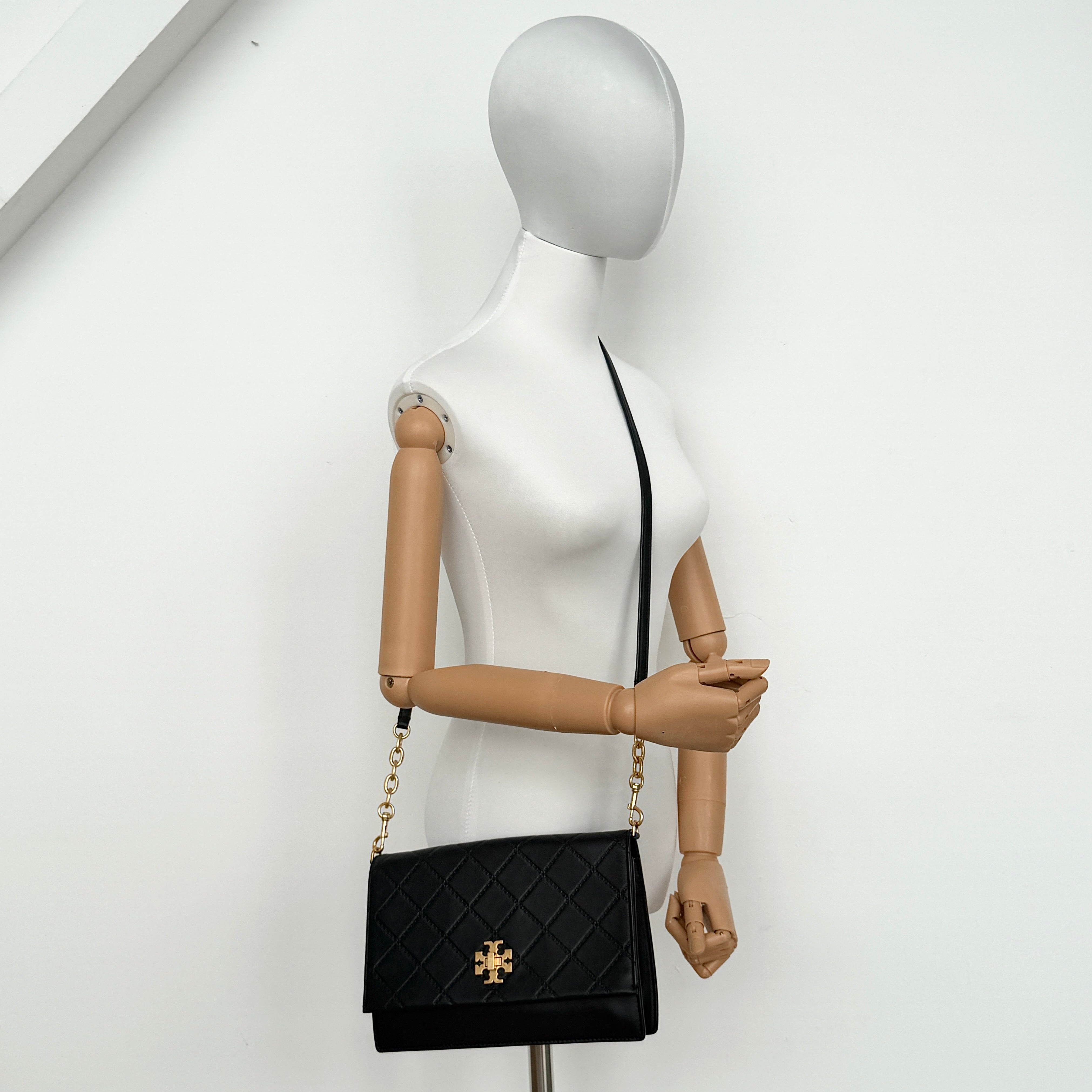 Tory Burch Georgia crossbody in black quilted leather with gold hardware, styled with adjustable chain and leather strap.