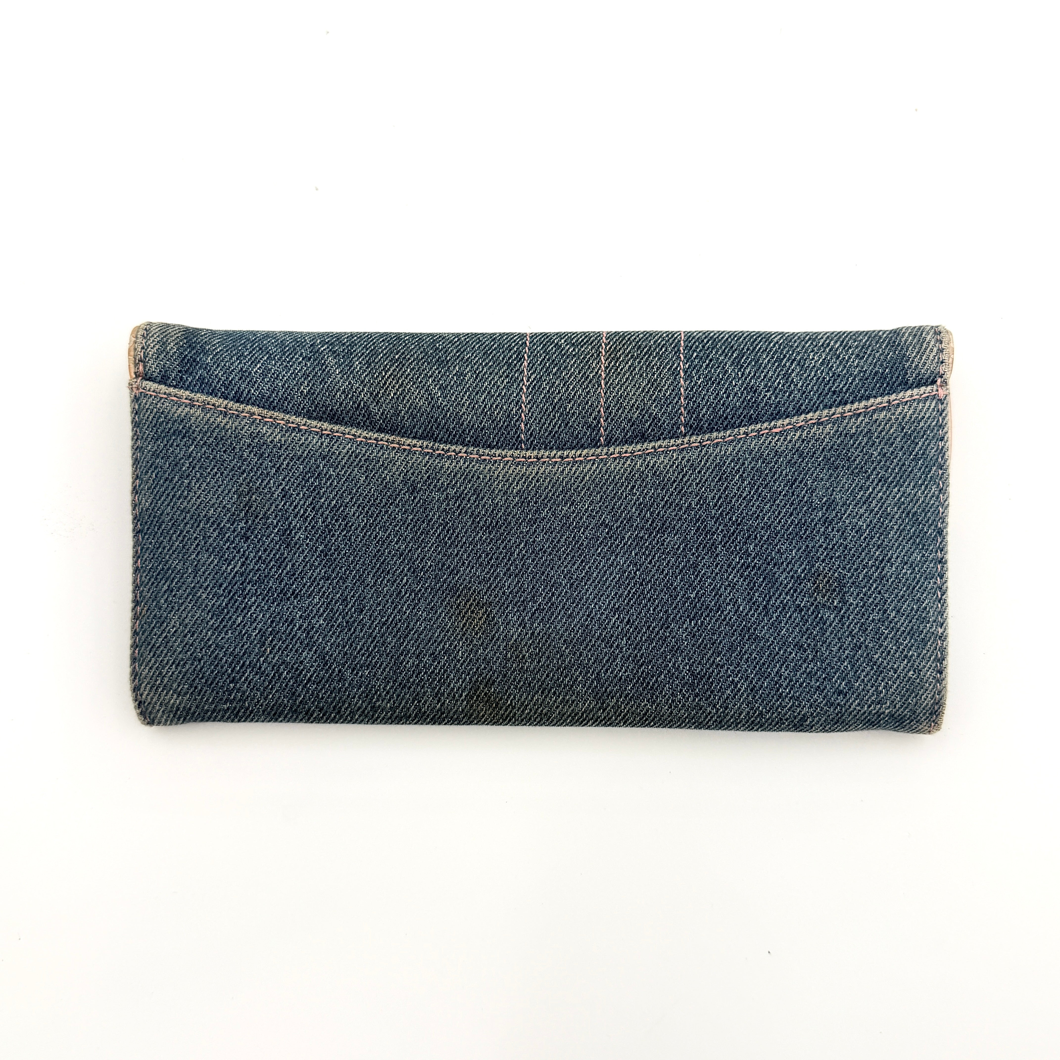 Dior Saddle Denim Wallet in blue denim with signature curved silhouette and silver-tone 'D' charm on the front flap.
