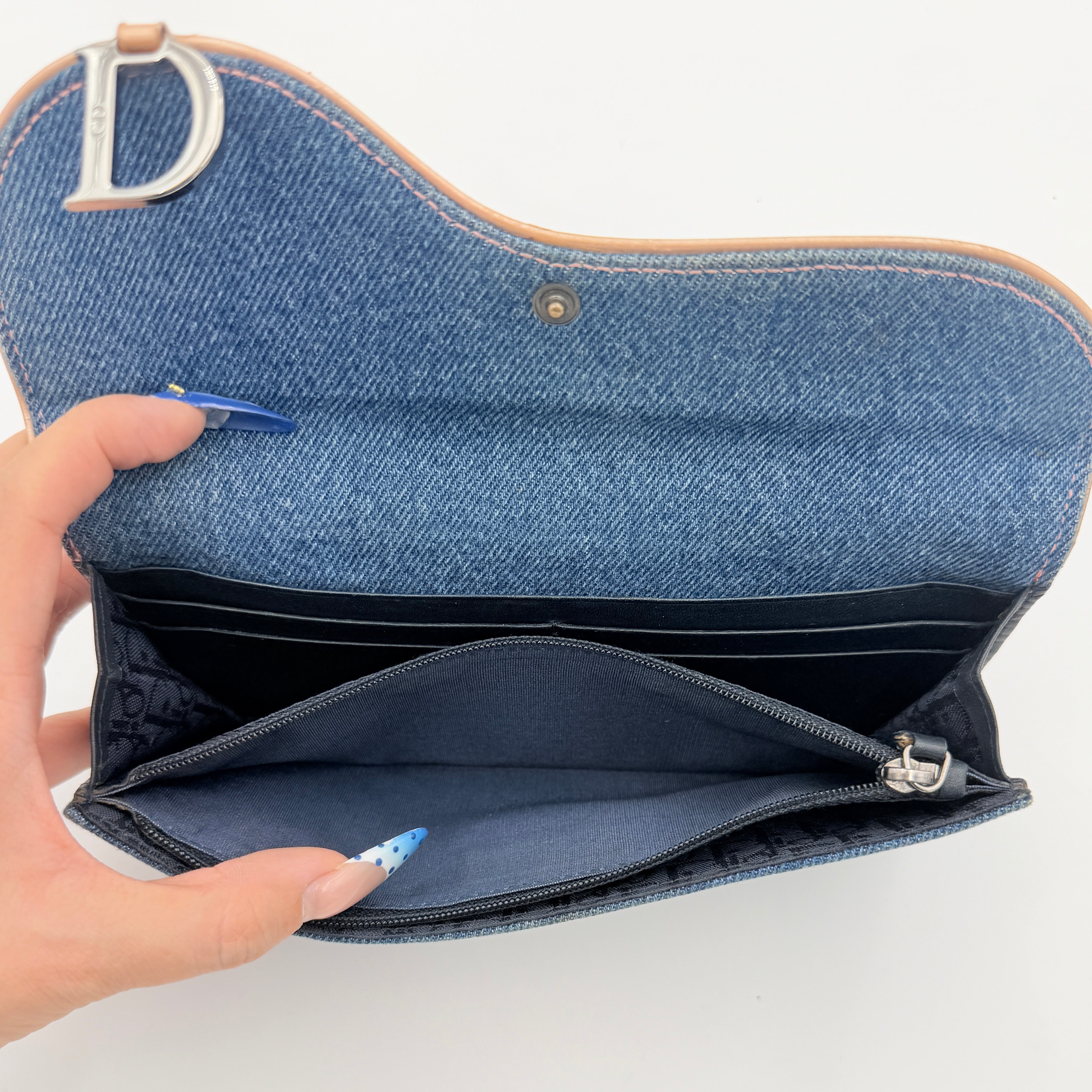 Dior Saddle Denim Wallet in blue denim with signature curved silhouette and silver-tone 'D' charm on the front flap.