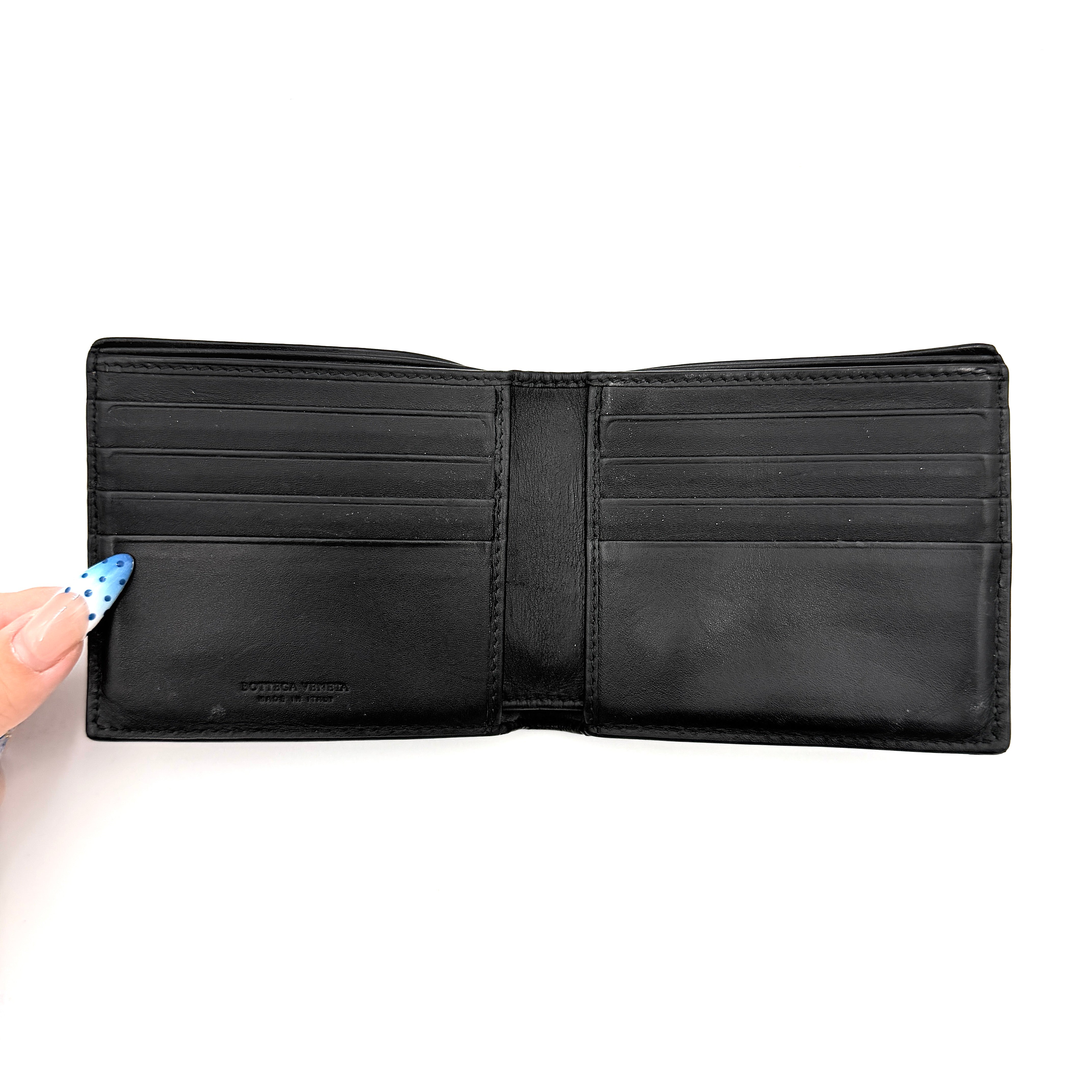 Bottega Veneta black intrecciato leather wallet shown against a plain background highlighting its woven texture.