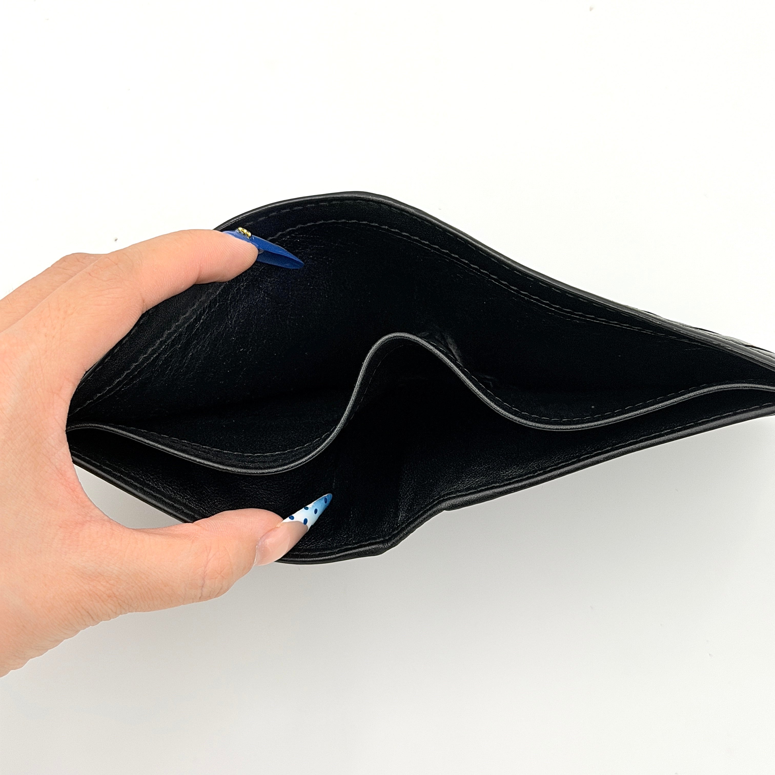 Bottega Veneta black intrecciato leather wallet shown against a plain background highlighting its woven texture.