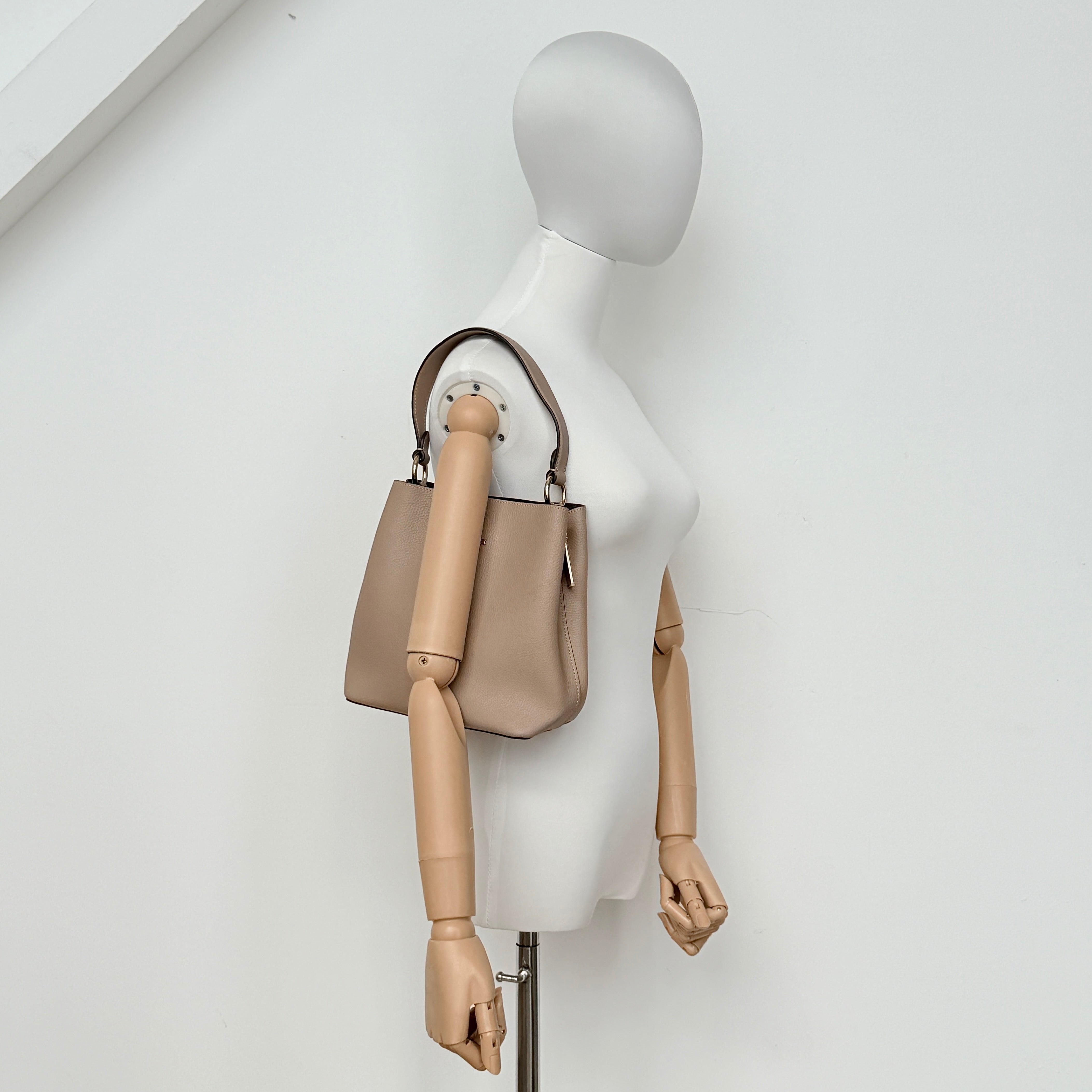Coach Town Bucket Bag in taupe pebbled leather with gold-tone hardware and Coach hangtag, shown against a white background.