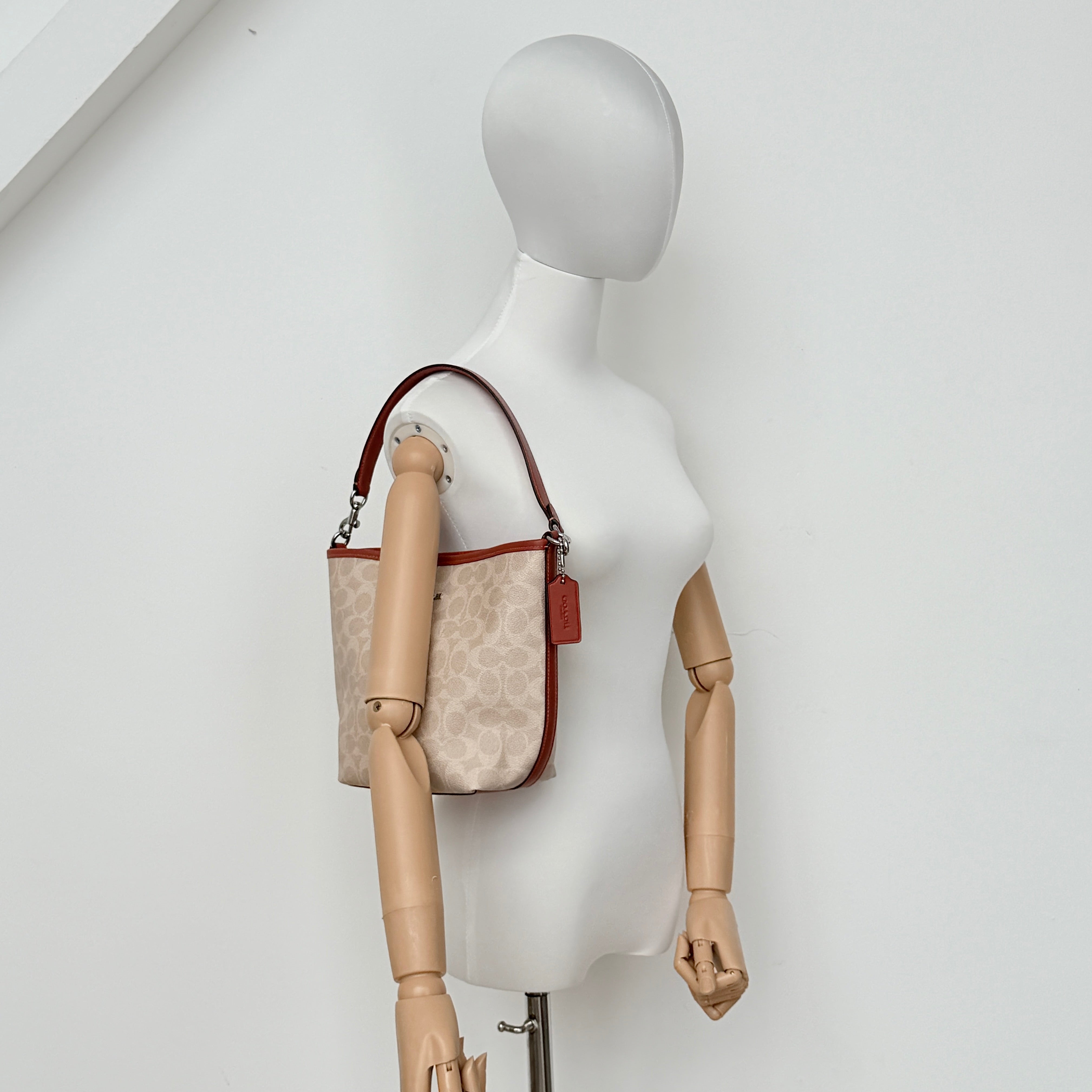 Coach 2Way City Bucket Shoulder Bag in beige signature canvas with red leather accents, detachable strap, and silver-tone hardware.
