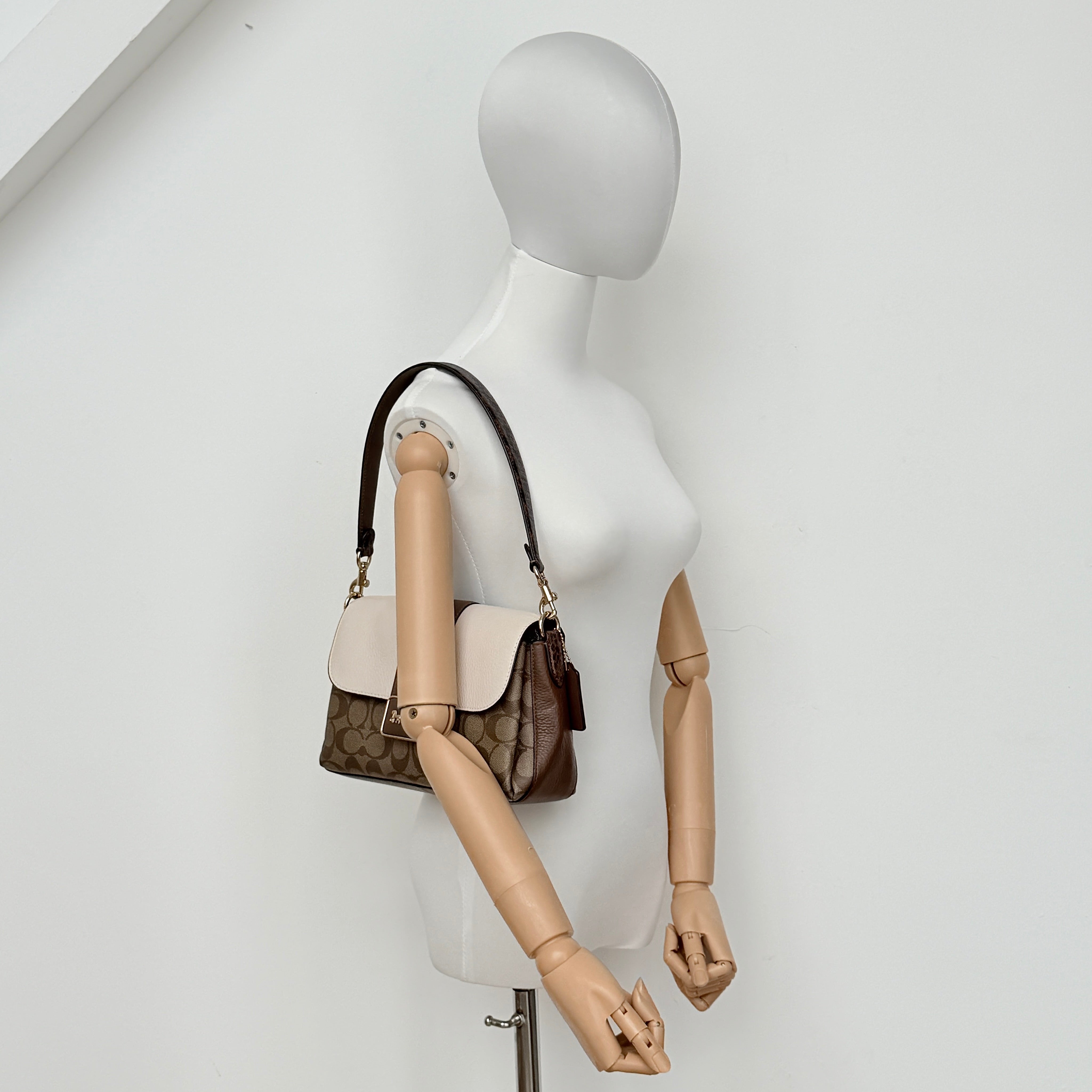 Coach Signature Grace Shoulder Bag in beige and white leather with monogram canvas and gold hardware, displayed with structured silhouette and top handle.