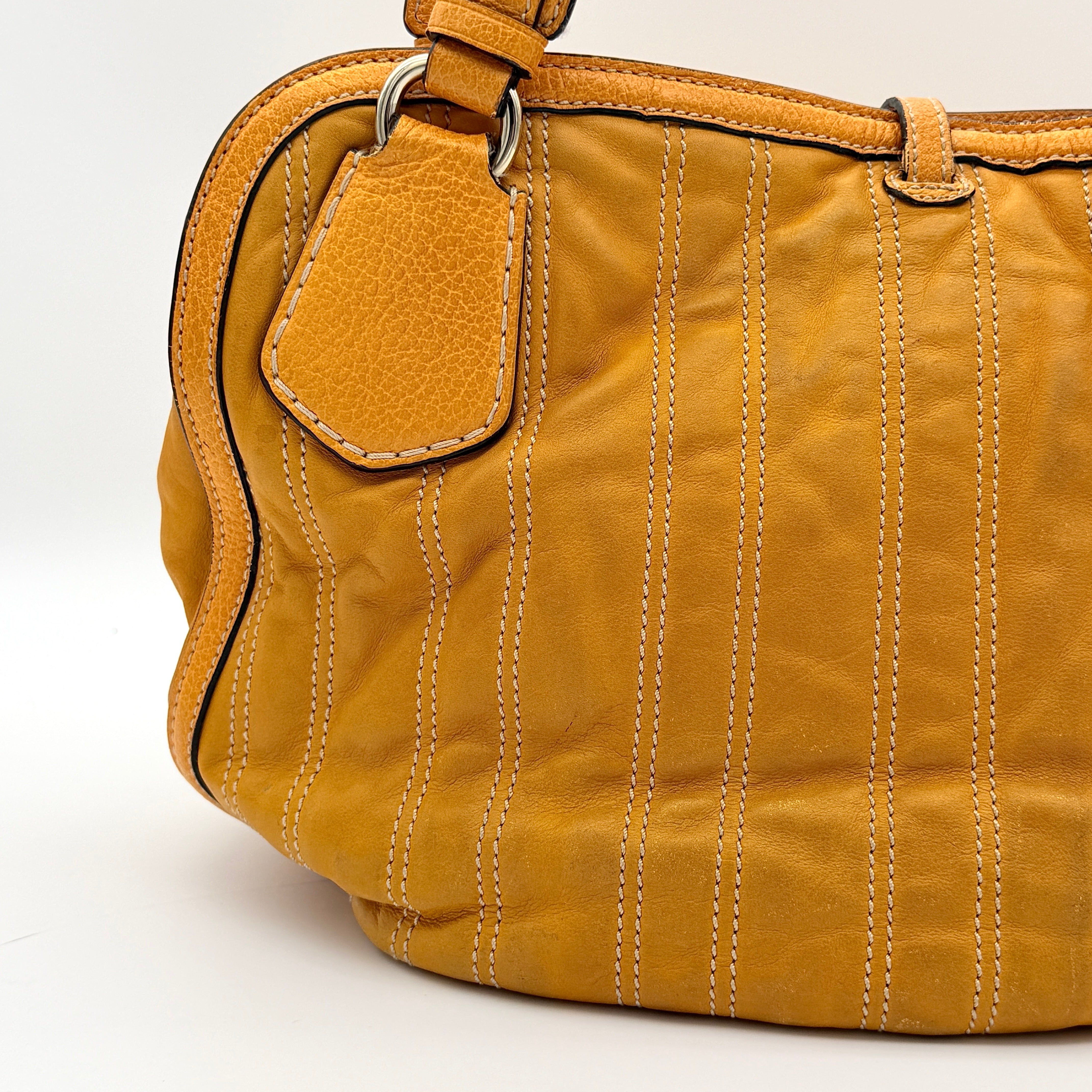 Celine Stripe Hobo Shoulder Bag in yellow leather with vertical stitching and signature gold-tone medallion, shown with dual handles.