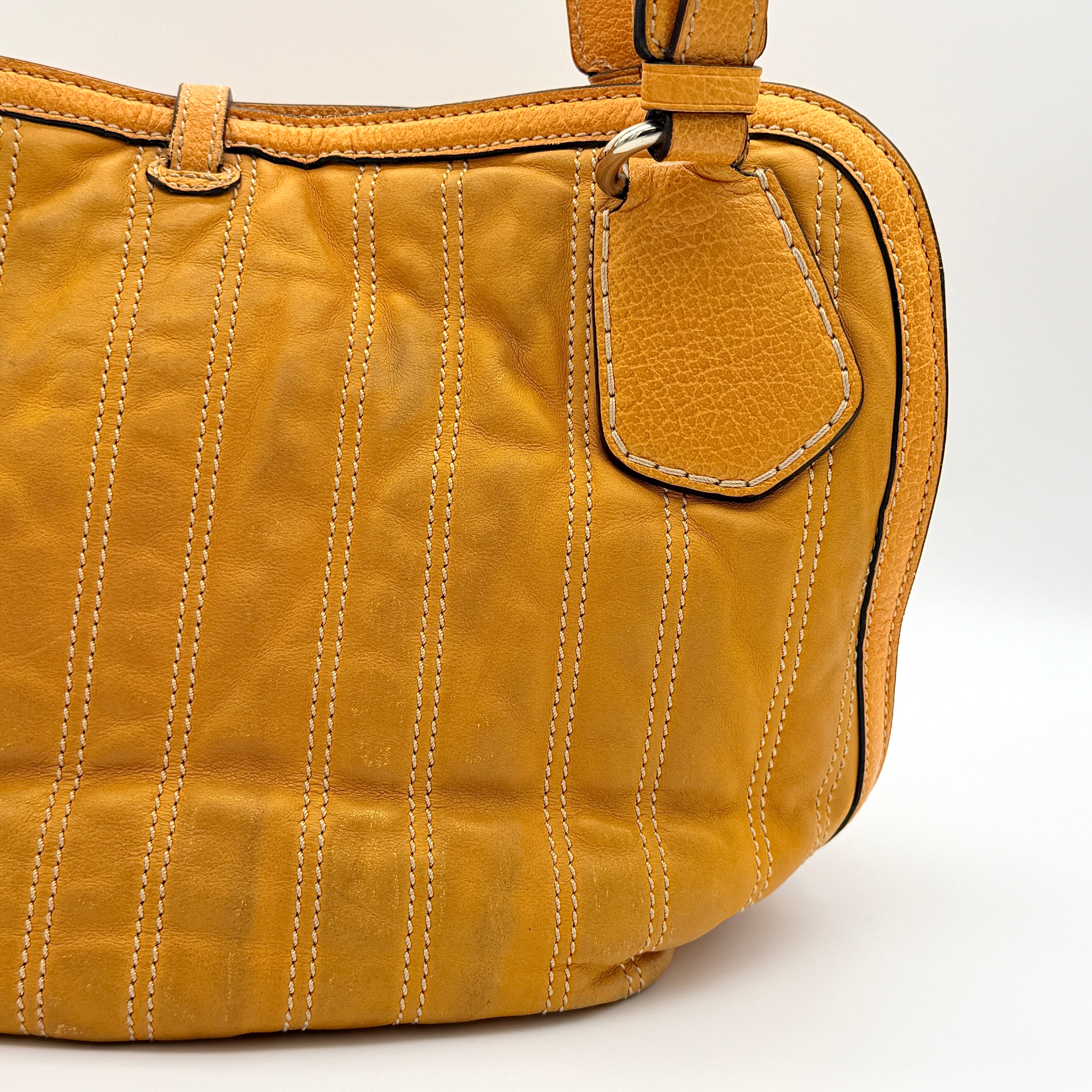 Celine Stripe Hobo Shoulder Bag in yellow leather with vertical stitching and signature gold-tone medallion, shown with dual handles.